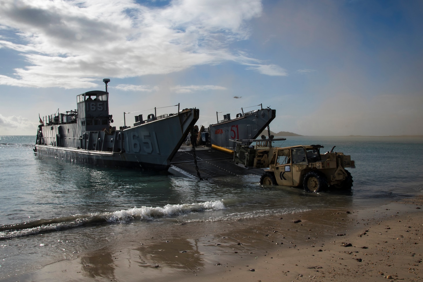170713-N-WF272-551 TOWNSHEND ISLAND, Australia (July 13, 2017) Sailors and Marines onboard Landing Craft Utility (LCU) 1651, assigned to Naval Beach Unit (NBU) 7, offload equipment as part of large-scale amphibious assault during Talisman Saber 17. The LCU, launched from the amphibious dock landing ship USS Ashland (LSD 48), enabled movement of 31st Marine Expeditionary Unit (MEU) forces and equipment ashore in order for the MEU to complete mission objectives in tandem with Australian counterparts. (U.S. Navy video by Mass Communication Specialist 2nd Class Diana Quinlan/Released)