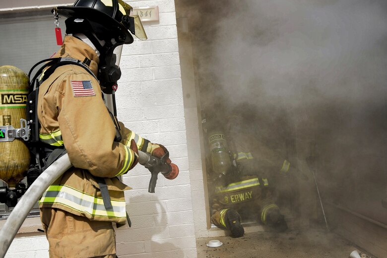 Staff Sgt. Blaine Erway, 99th Civil Engineer Squadron firefighter crew chief, and Airman 1st Class Brian Velten, 99th CES firefighter, prepare to enter a simulated house fire during Red Flag 17-3 at Nellis Air Force Base, Nev., July 18, 2017. The simulation tasked the pair with entering the house and recovering a dummy. (U.S. Air Force photo by Airman 1st Class Andrew D. Sarver/Released)
