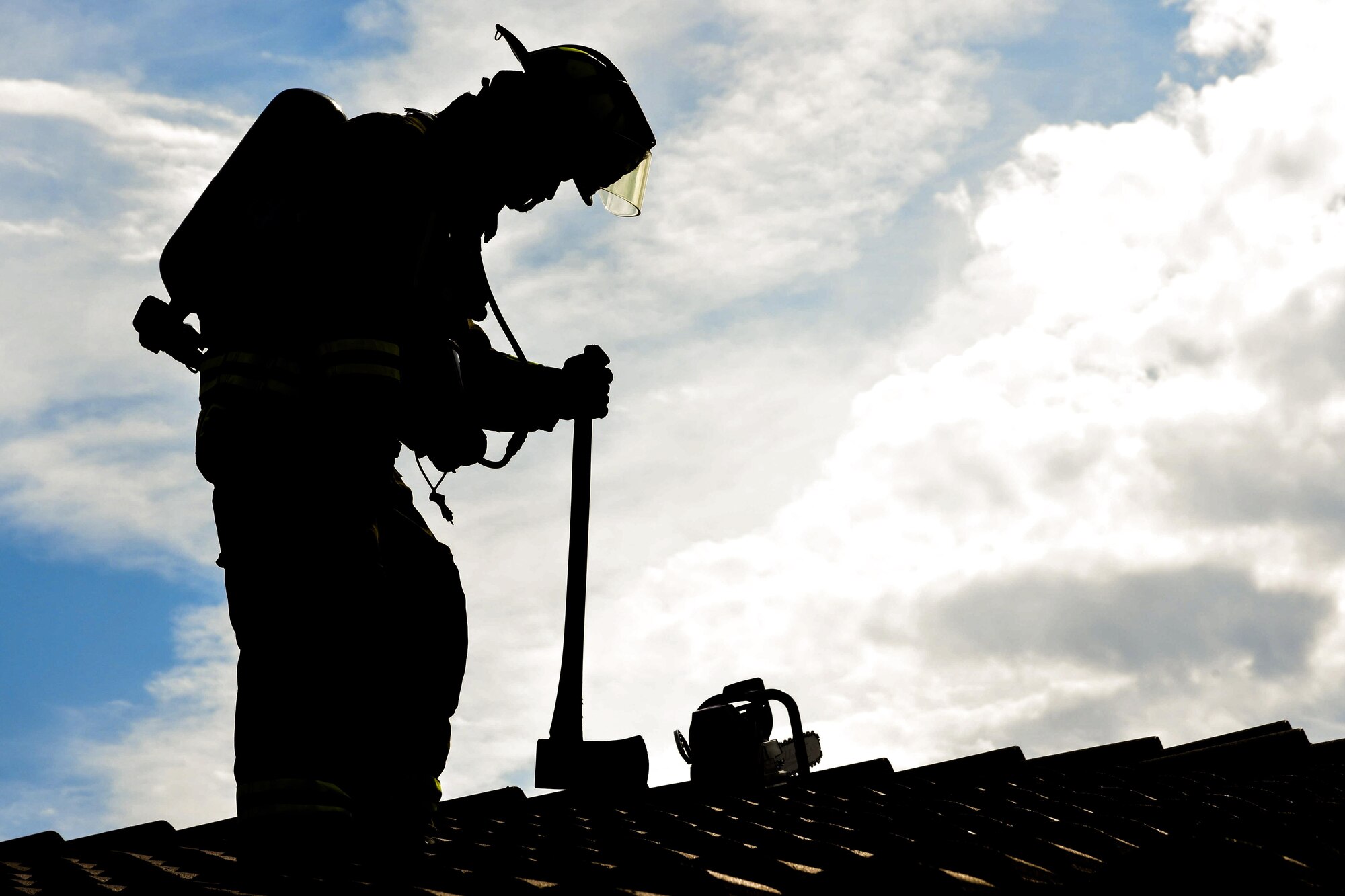 Airman 1st Class Adam Striejewski, 99th Civil Engineer Squadron firefighter, checks the roof of a simulated house fire during Red Flag 17-3 at Nellis Air Force Base, Nev., July 18, 2017. The increase of the base population during Red Flag exercises results in increased emergency calls to the fire department for anything from a minor medical emergency to a major flightline incident. (U.S. Air Force photo by Airman 1st Class Andrew D. Sarver/Released)