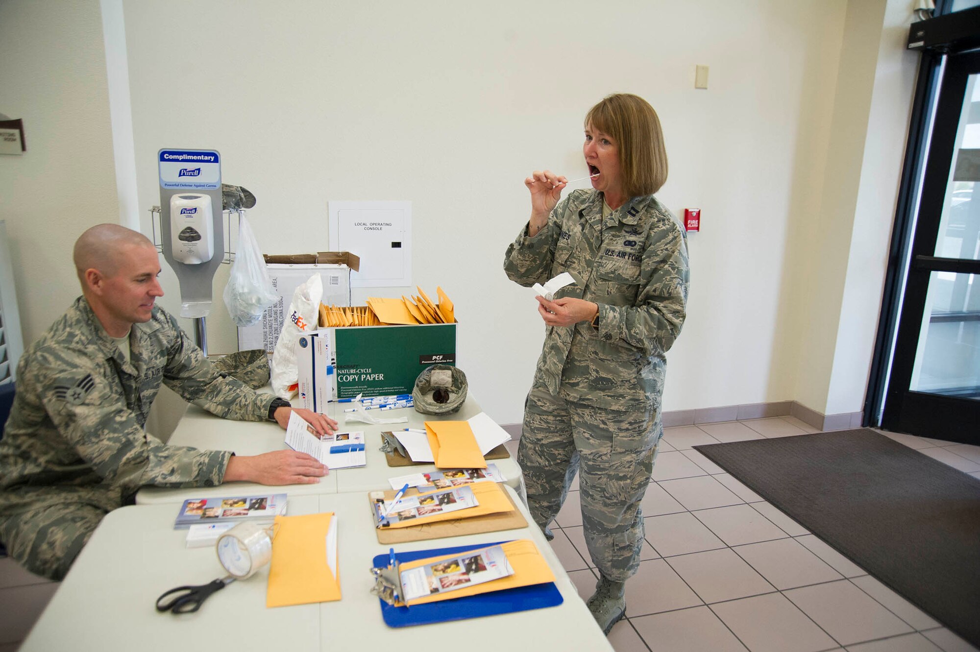 (Right) Capt. Tammy Jones, 926th Wing Executive Officer, swabs her cheek before submitting a bone marrow donor registration packet to Senior Airman Brent Montgomery, 926th Force Support Squadron personnelist and drive volunteer, during a Salute to Life drive June 3 at Nellis Air Force Base, Nevada. (U.S. Air Force photo/Senior Airman Alexandria Slade)