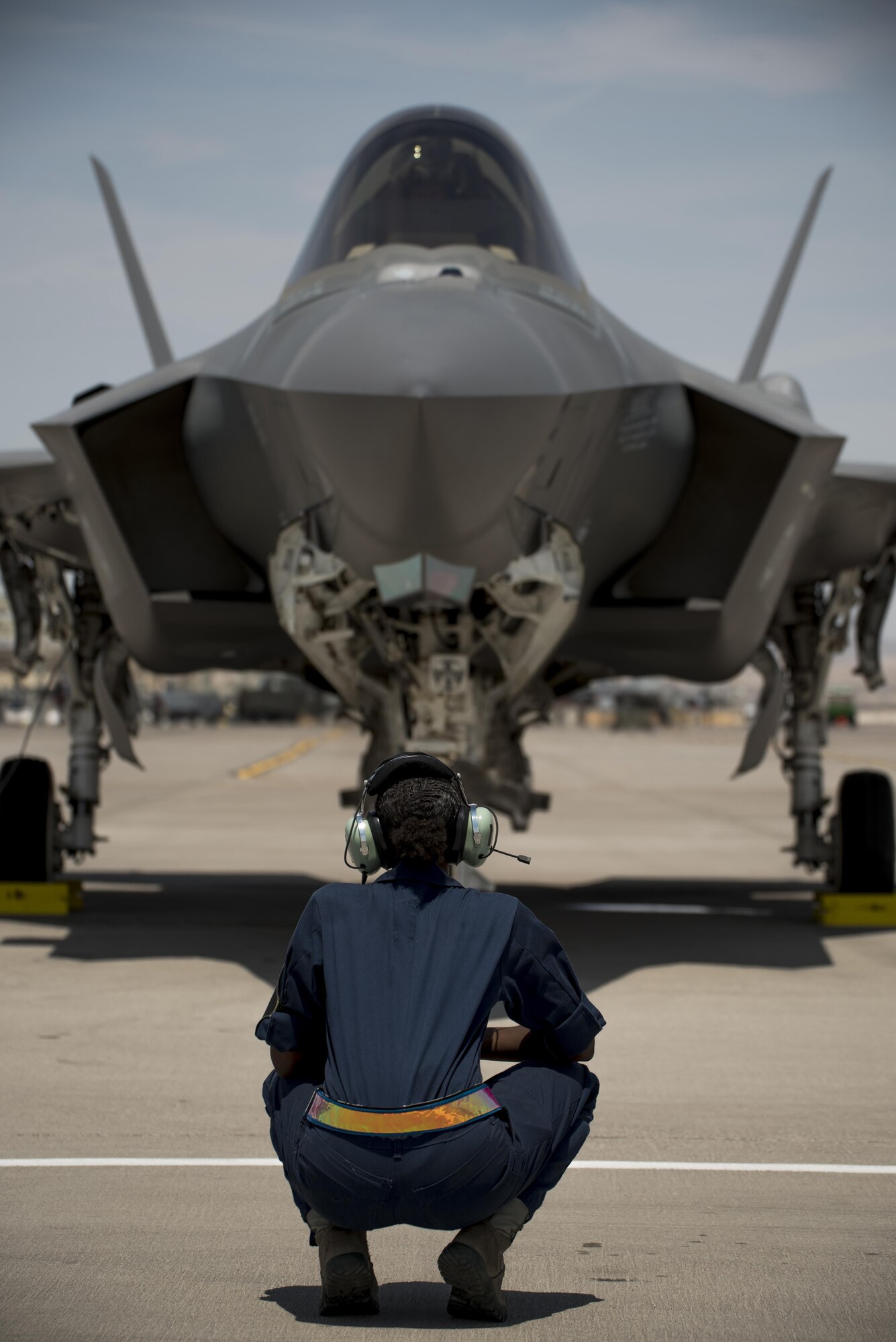 U.S. Air Force Senior Airman Carol Sims, 33rd Aircraft Maintenance Squadron assistant dedicated crew chief, crouches in front of an F-35A Lightning II July 18, 2017, at Nellis Air Force Base, Nev. The 33rd Fighter Wing and Marine Attack Squadron 221 from Yuma, Ariz., participated in the first combat exercise with Air Force F-35As and Marine Corps F-35Bs operating simultaneously during Red Flag 17-3. The large scale exercise, which was developed to provide pilots with critical experience in combat situations, enabled F-35 pilots to plan and train using the same tactics, techniques and procedures. (U.S. Air Force photo by Staff Sgt. Peter Thompson)