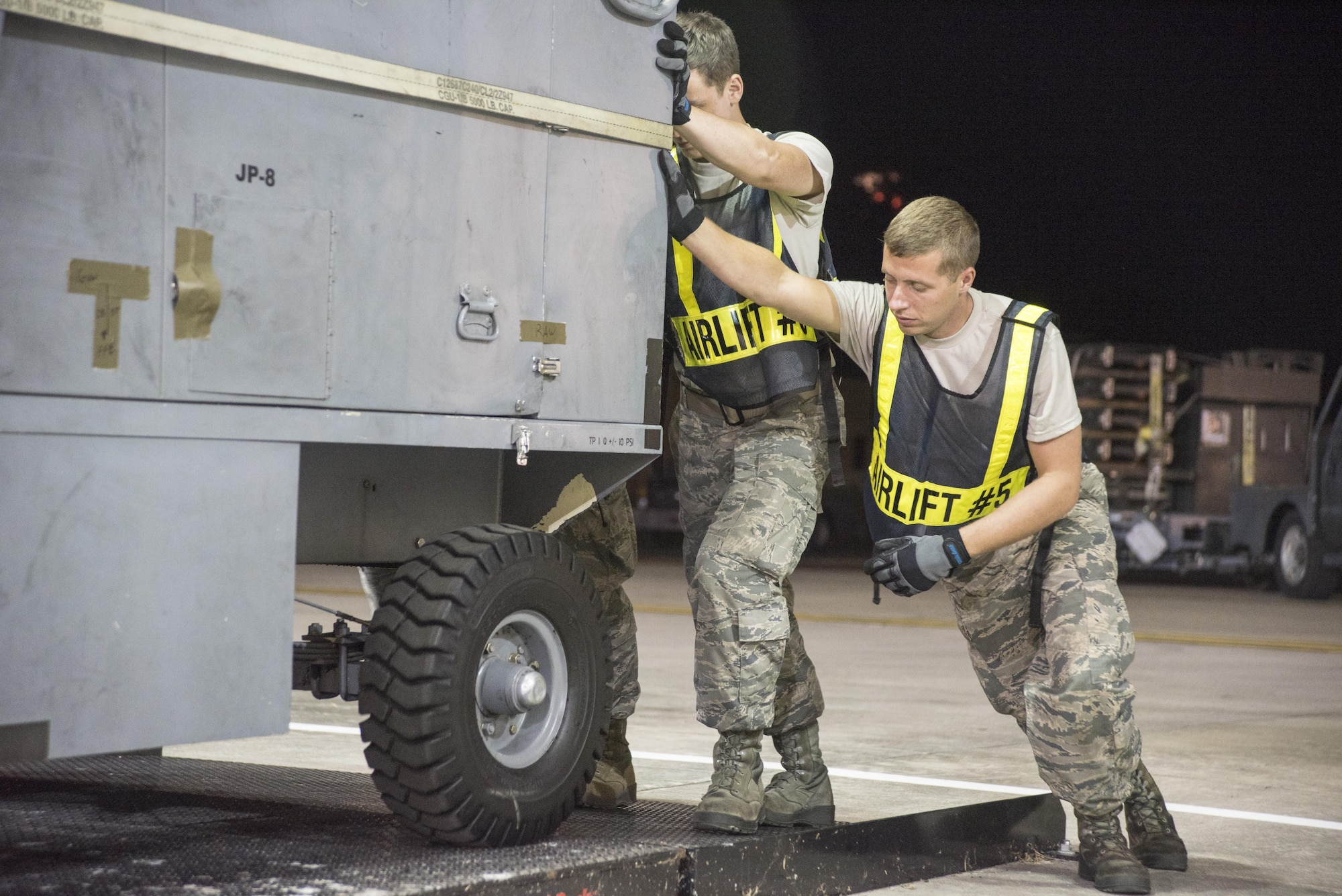 Crew chiefs with the 4th Aircraft Maintenance Squadron push a hydrogen cart into a vehicle roll-on scale July 20, 2017, at Seymour Johnson Air Force Base, North Carolina. With the help of travel management office, the crew chiefs were able to weigh the cart prior to being loaded onto the aircraft. (U.S. Air Force photo by Tech. Sgt. David W. Carbajal)