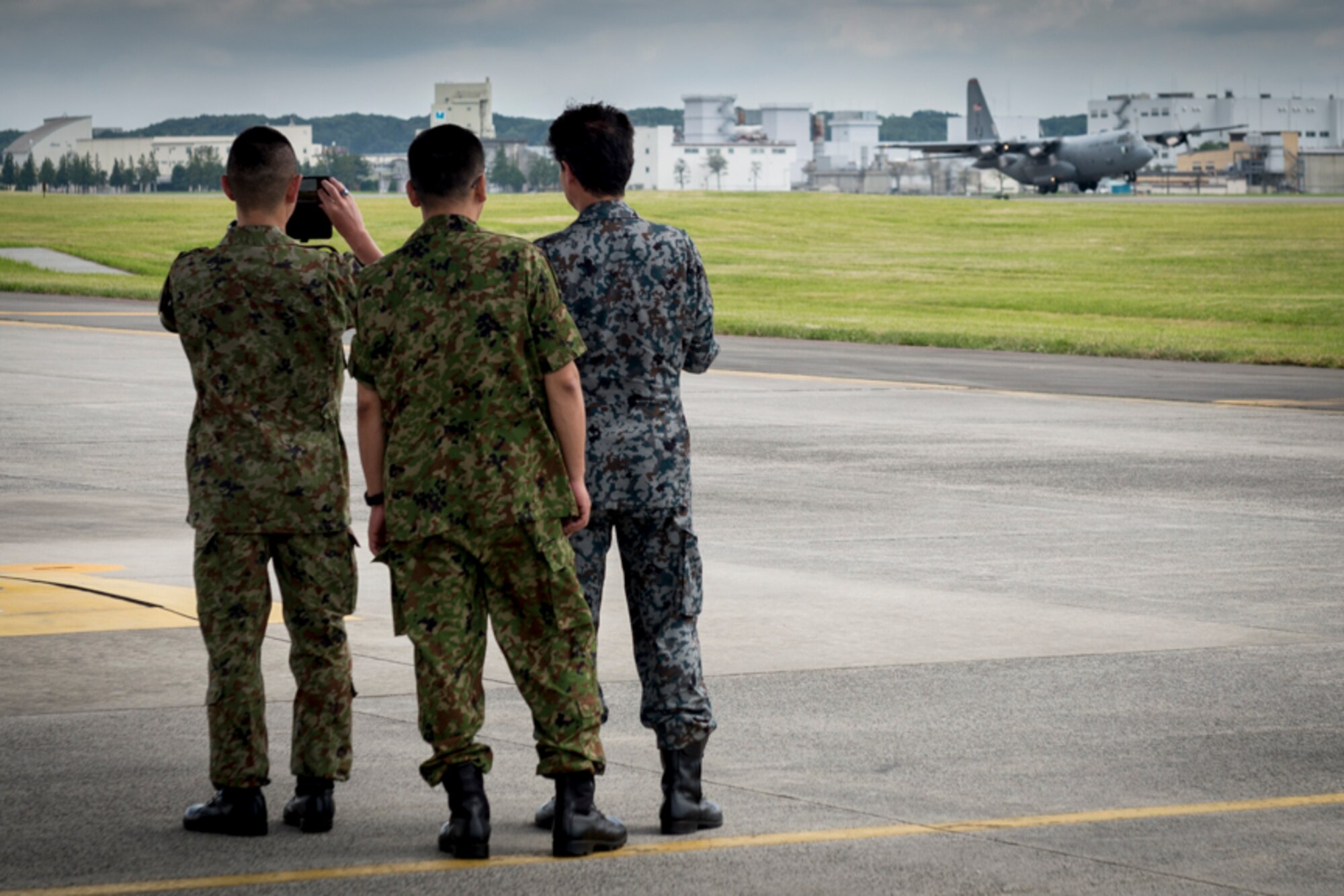 Attendants of a U.S. Forces, Japan and Japan Self-Defense Forces' Senior Enlisted Leader Symposium watch a U.S. Air Force C-130H Hercules takeoff during a C-130J Super Hercules tour, July 14, 2017, at Yokota Air Base, Japan. The Symposium was a two-day event in which USFJ and JSDF component SELs discuss various enlisted leadership development programs, enhancing the coordination between U.S. and Japan, among other topics of mutual concern throughout the Indo-Asia Pacific region. (U.S. Air Force photo by Airman 1st Class Juan Torres)