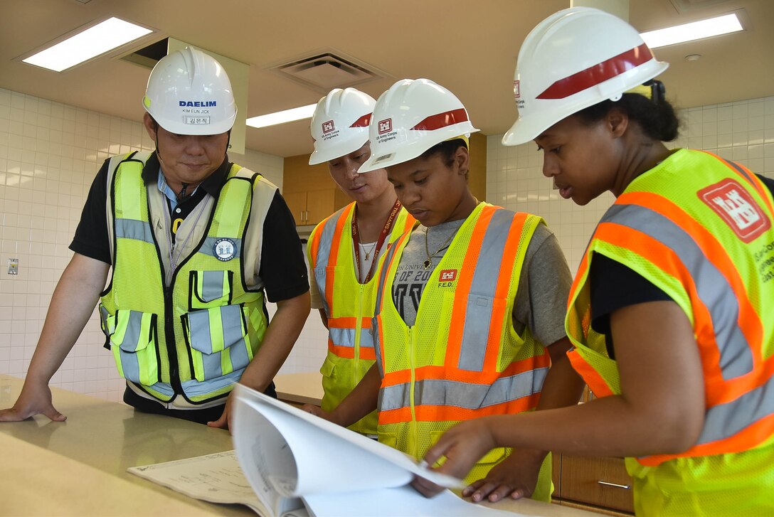 Joyrie Dickerson, center, a chemical engineering major from Hampton University, looks over a design package during a site visit July 20 at Camp Humphreys, South Korea.