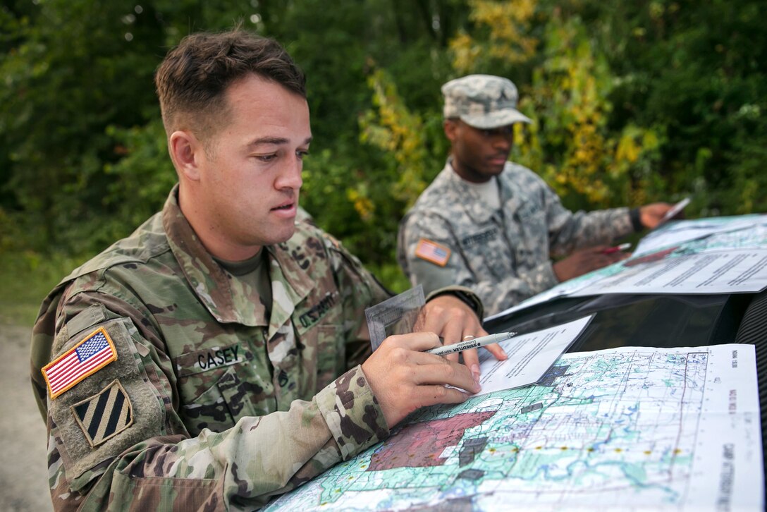 Army Staff Sgt. Jared Casey determines the grid coordinate of a point on a map during day land navigation at Camp Atterbury, Ind., July 18, 2017, during Army Materiel Command's Best Warrior Competition. Casey is assigned to the 409th Contracting Support Brigade. Army photo by Sgt. 1st Class Teddy Wade