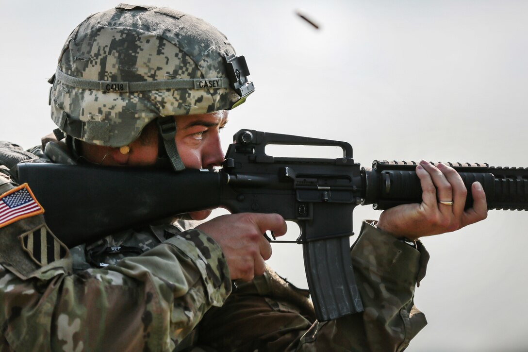 Army Staff Sgt. Jared Casey fires an M16 rifle from the kneeling position during a weapons qualification range at Camp Atterbury, Ind., July 18, 2017, during Army Materiel Command's Best Warrior Competition. Casey is assigned to the 409th Contracting Support Brigade. Army photo by Sgt. 1st Class Teddy Wade