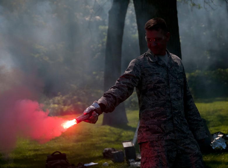 Master Sgt. Braden Duszynski, a munitions specialist with the 128th Air Refueling Wing, holds a signal flare during aircrew survival training at Grant Park in Milwaukee, Wisc., July 15, 2017.  This survival training is designed to instruct Airmen on how to endure threatening survival scenarios. (U.S. Air National Guard photo by Senior Airman Morgan R. Lipinski/Released)