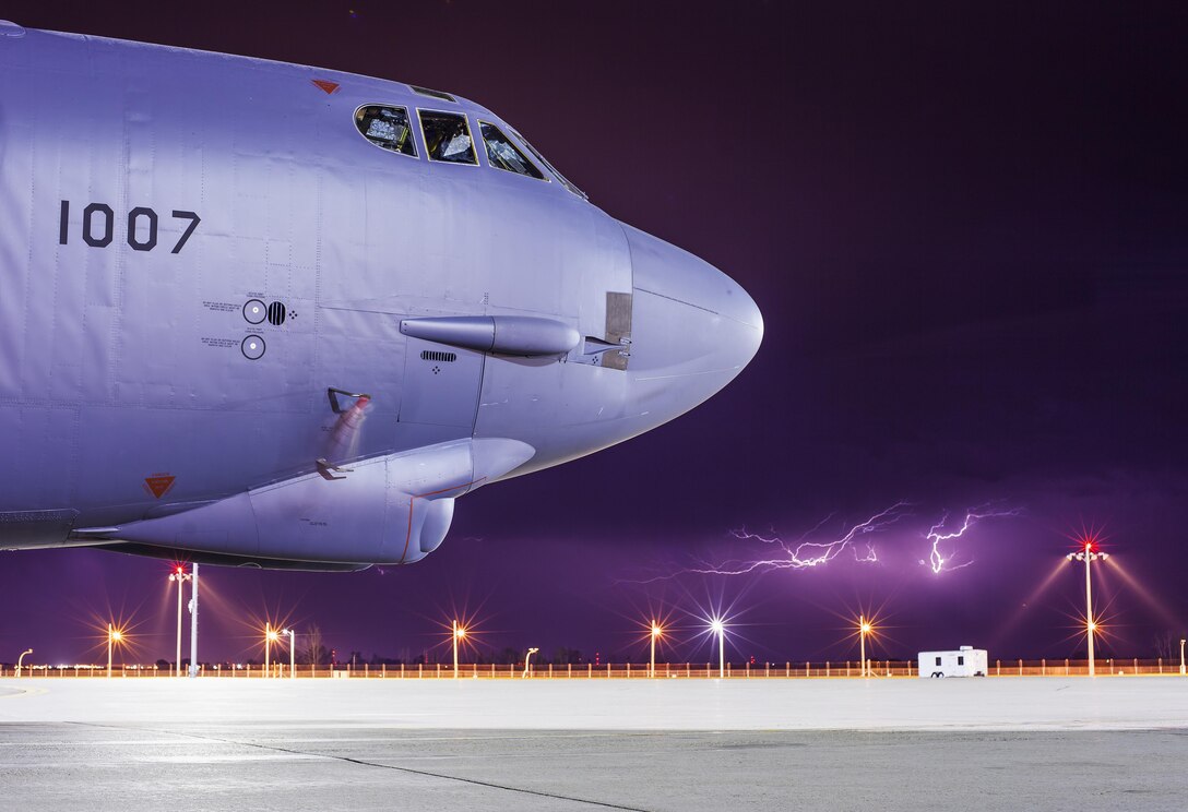 Lightning strikes behind a B-52H Stratofortress at Minot Air Force Base, N.D., July 17, 2017. The B-52 is a long-range, heavy bomber that can carry nuclear-capable or precision-guided conventional ordnance with worldwide precision navigation capability. (U.S. Air Force photo/Senior Airman J.T. Armstrong)