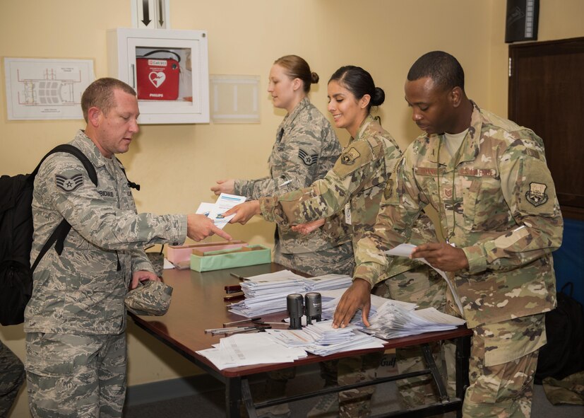 Staff Sgt. Beatriz Zapien, a personnelist assigned to the 386th Expeditionary Force Support Squadron Personnel Support for Contingency Operations sustainment team assists a newcomer with paperwork during an in-processing briefing at an undisclosed location in Southwest Asia, July 16, 2017. PERSCO conducts in-processing briefings with all inbound personnel to ensure 100% accountability as well as to provide a one stop shop for briefings and paperwork processing. (U.S. Air Force photo by Tech. Sgt. Jonathan Hehnly)
