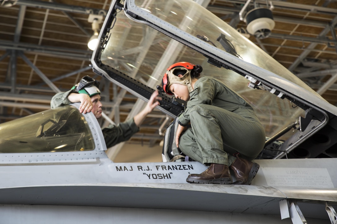 U.S. Marine Corps Sgt. Dominic Schulte, left, a flight equipment technician with Marine Fighter Attack Squadron (VMFA) 232, teaches Lance Cpl. Dahee Park, an aircraft rescue firefighter with Headquarters and Headquarters Squadron, the ins and outs of the cockpit in an F/A-18C Hornet at Marine Corps Air Station Iwakuni, Japan, July 19, 2017. Aircraft Rescue and Firefighting Marines visited the aircraft display to familiarize themselves with the aircraft so they can be more efficient in emergency situations. (U.S. Marine Corps Lance Cpl. Gabriela Garcia-Herrera)