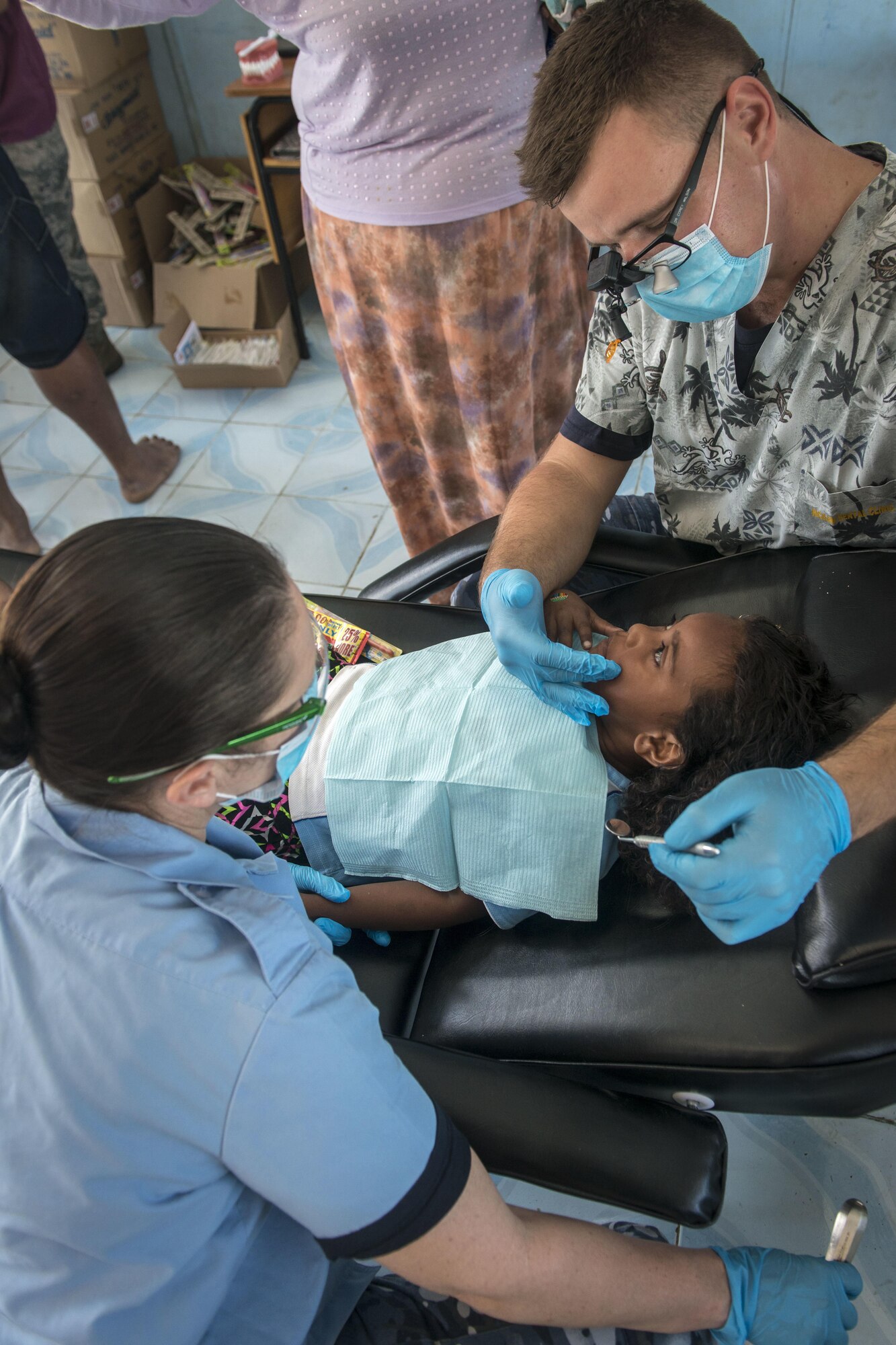 Royal Australian Air Force (RAAF) Flt. Lt. Corey Wilson, right, a dental officer with the 2nd Expeditionary Health Services Wing at RAAF Base Williamtown, Australia, asks his patient to open her mouth as RAAF Leading Aircraft Woman Amanda Walters, left, the senior dental assistant with the Joint Health Command in Wagga Wagga, Australia, waits to hand him tools during Pacific Angel (PACANGEL) 17-3 at Tagitagi Sangam School and Kindergarten in Tavua, Fiji, July 17, 2017. The duo worked side-by-side with their Fijian and U.S. partners to ensure the local community receives dental care as part of the humanitarian assistance exercise PACANGEL 17-3, that has been conducted since 2007. (U.S. Air Force photo/Tech. Sgt. Benjamin W. Stratton)