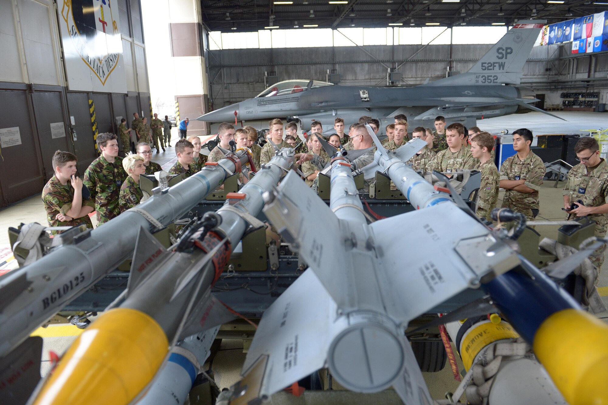 Master Sgt. Jason Tremmel, 52nd Maintenance Group loading standards crew team chief, talks about the munitions that go on the F-16 Fighting Falcon to Royal Air Force Air Cadets at Spangdahlem Air Base, Germany, July 20, 2017. The cadets visited several different squadrons around base to give them a glimpse into U.S. Air Force operations. (U.S. Air Force photo by Staff Sgt. Jonathan Snyder)