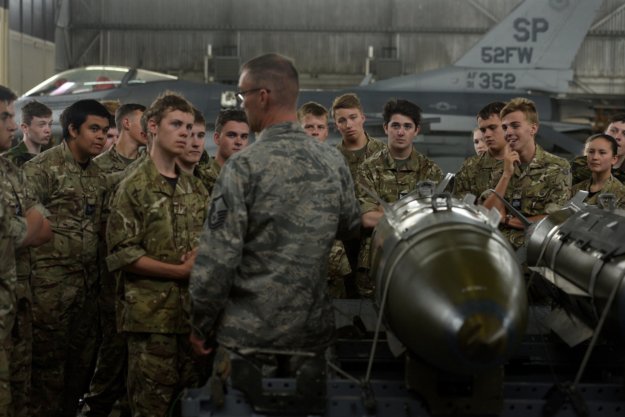 Master Sgt. Jason Tremmel, 52nd Maintenance Group loading standards crew team chief, talks about the munitions that go on the F-16 Fighting Falcon to Royal Air Force Air Cadets at Spangdahlem Air Base, Germany, July 20, 2017. The cadets visited several different squadrons around base to give them a glimpse into U.S. Air Force operations. (U.S. Air Force photo by Staff Sgt. Jonathan Snyder)