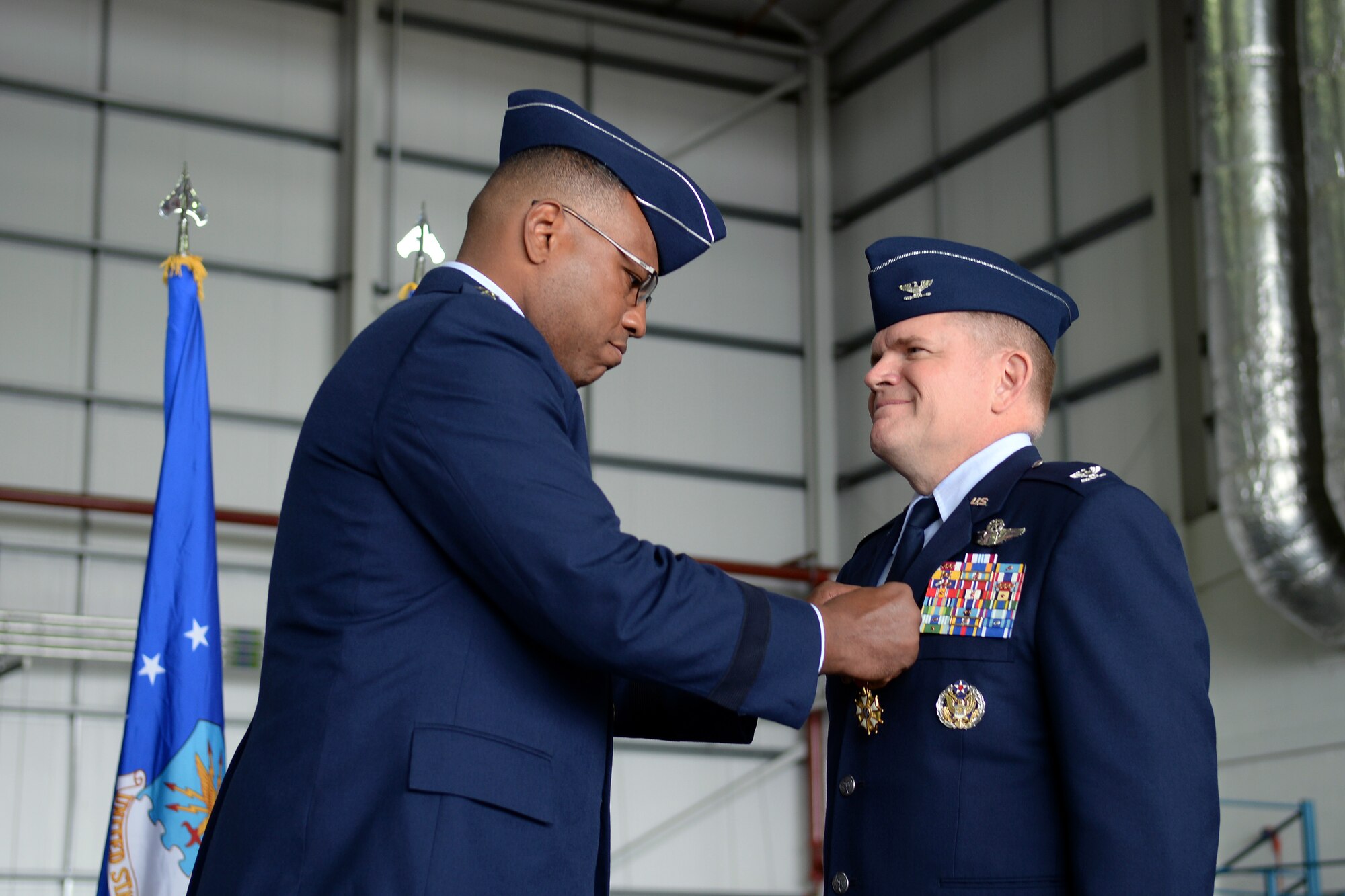 U.S. Air Force Lt. Gen. Richard M. Clark, 3rd Air Force commander, pins the Legion of Merit medal on U.S. Air Force Col. Thomas D. Torkelson, 100th Air Refueling Wing outgoing commander July 21, 2017, on RAF Mildenhall, England. The Legion of Merit award represents exceptionally meritorious conduct in the performance of outstanding service and achievements. (U.S. Air Force photo by Airman 1st Class Luke Milano)