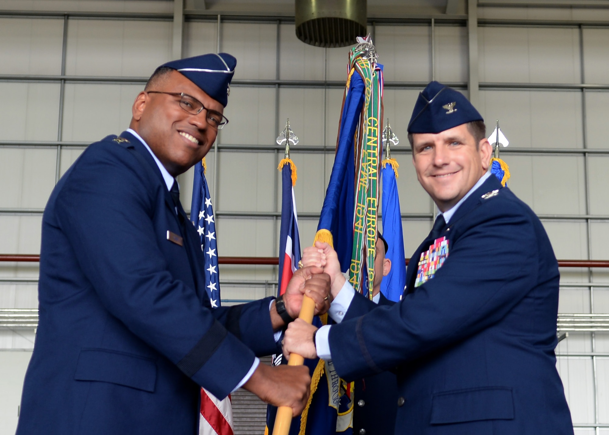 U.S. Air Force Lt. Gen. Richard M. Clark, 3rd Air Force commander, gives command of the 100th Air Refueling Wing to U.S. Air Force Col. Christopher R. Amrhein, 100th ARW commander, during the 100th ARW change of command ceremony July 21, 2017, on RAF Mildenhall, England. The passing of the unit guidon during a change of command ceremony is symbolic representation of passing authority to the incoming commander. (U.S. Air Force photo by Airman 1st Class Luke Milano)