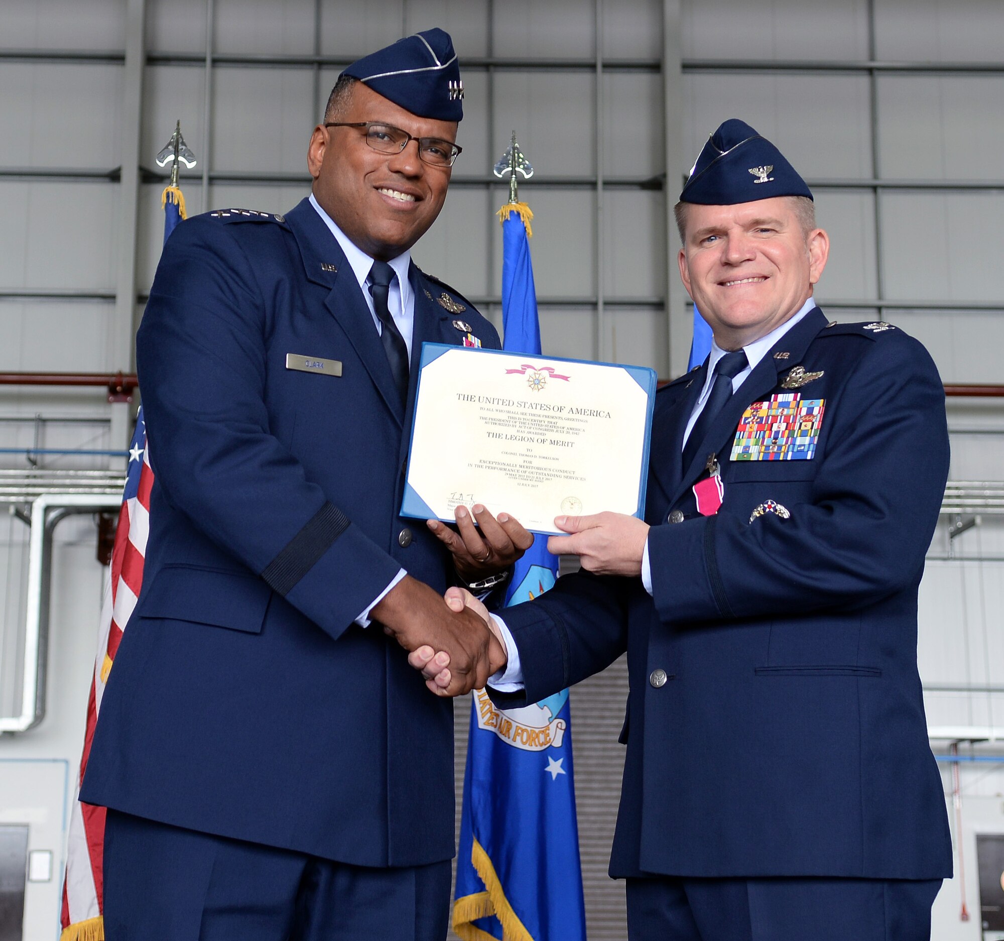 U.S. Air Force Lt. Gen. Richard M. Clark, 3rd Air Force commander, presents U.S. Air Force Col. Thomas D. Torkelson, 100th Air Refueling Wing outgoing commander, the Legion of Merit award July 21, 2017 on RAF Mildenhall, England. Torkelson commanded the 100th ARW for over two years, the only air refueling wing in the European theater. (U.S. Air Force photo by Airman 1st Class Luke Milano)