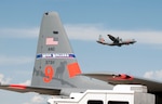 A California Air National Guard C-130 aircraft flies by a Nevada Air National Guard C-130 during this week's Modular Airborne Fire Fighting System training and certification. More than 400 personnel of four C-130 Guard and Reserve units — from California, Colorado, Nevada and Wyoming, making up the Air Expeditionary Group — are in Boise, Idaho for the week-long wildfire training and certification sponsored by the U.S. Forest Service.