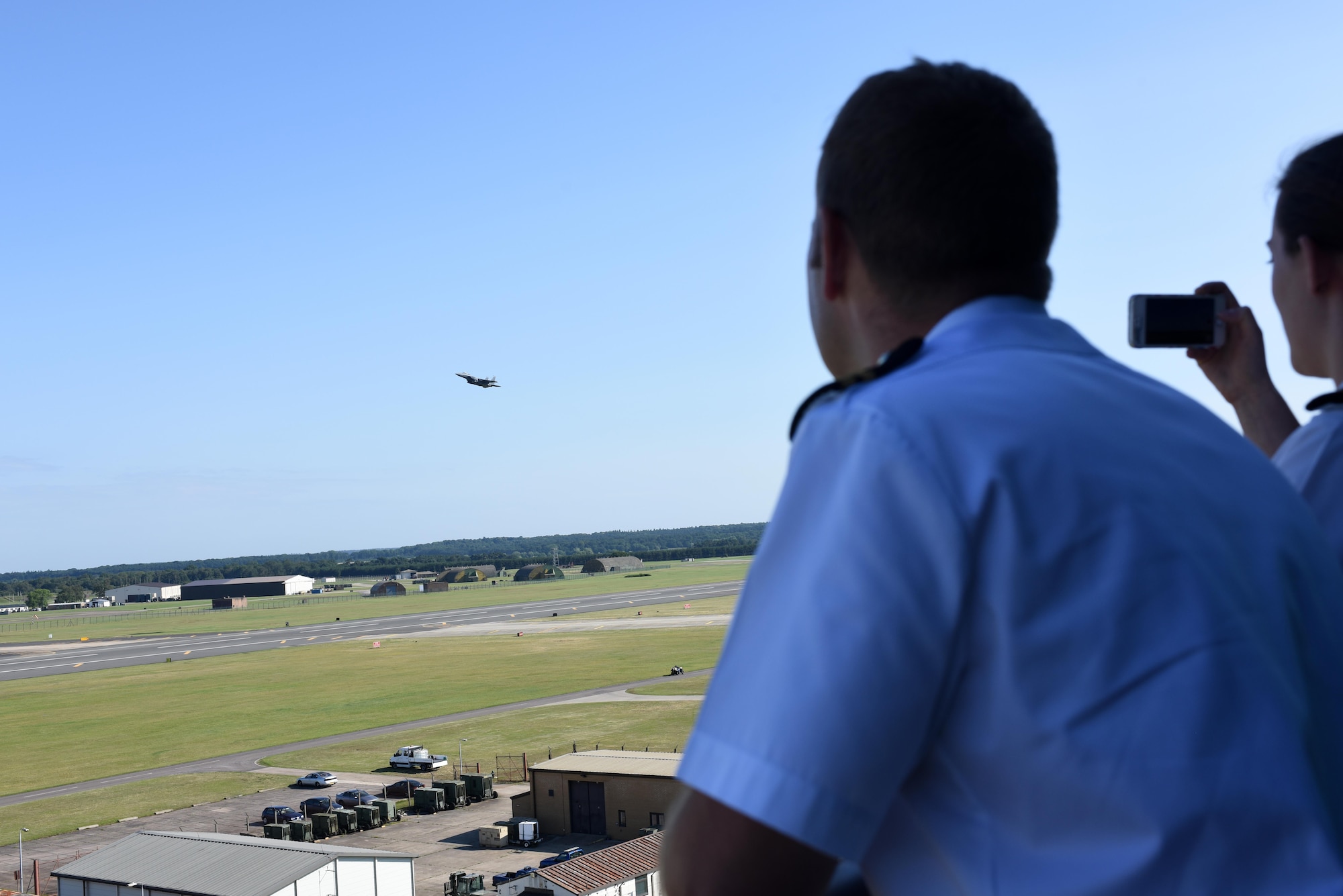 Fighter controllers and air warfare officers from the Royal Navy watch as F-15E Strike Eagles take off over Royal Air Force Lakenheath, England, July 13. The Royal Navy officers visited the Liberty Wing as part of their initial training to help them to understand capabilities of aircraft they may encounter in their careers as fighter controllers. (U.S. Air Force photo/Airman 1st Class Eli Chevalier)