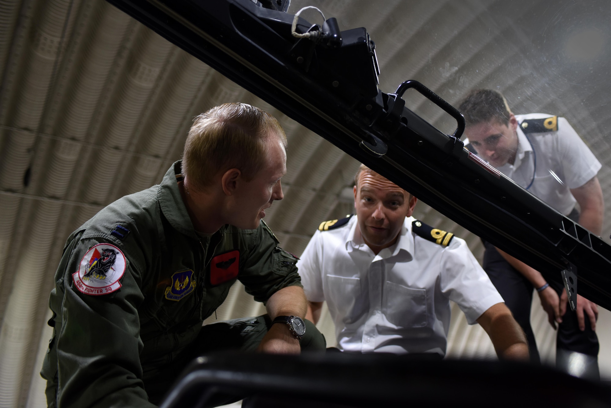 Fighter controllers and air warfare officers from the Royal Navy receive an F-15E Strike Eagle capabilities brief from a pilot assigned to the 494th Fighter Squadron at Royal Air Force Lakenheath, England, July 13. The Royal Navy officers visited the Liberty Wing as part of their initial training to help them to understand capabilities of aircraft they may encounter in their careers as fighter controllers. (U.S. Air Force photo/Airman 1st Class Eli Chevalier) (Portions of this image have been blurred to protect operational security)