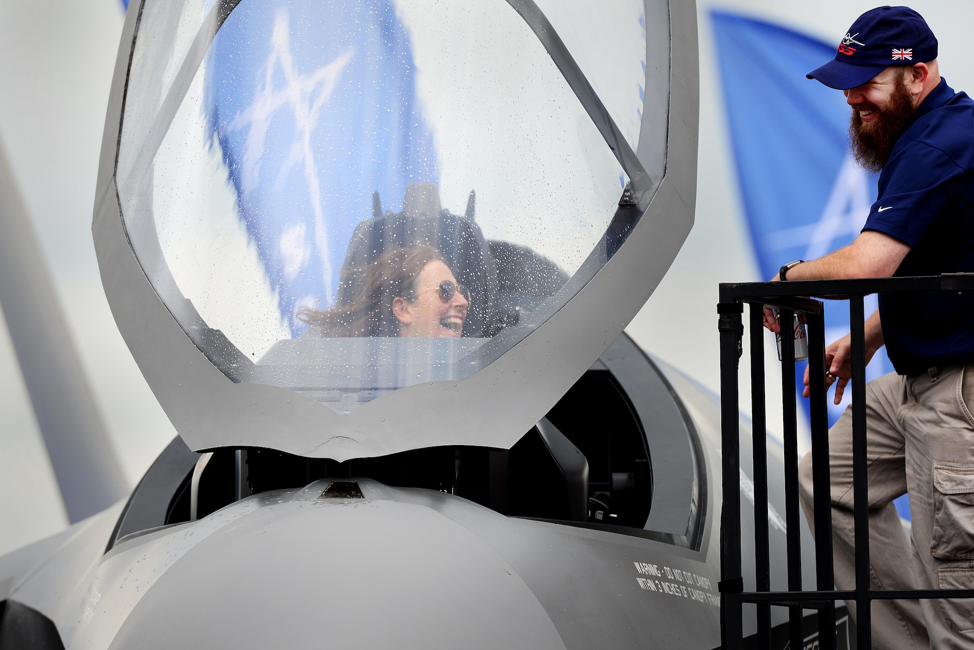 A young woman smiles as she sits in a scale model F-35B Lightning II cockpit during Friends & Families Day at Royal Air Force Marham, England July 20. RAF Marham is expected to get their first crop F-35Bs in 2018. (U.S. Air Force photo/ Tech. Sgt. Matthew Plew)