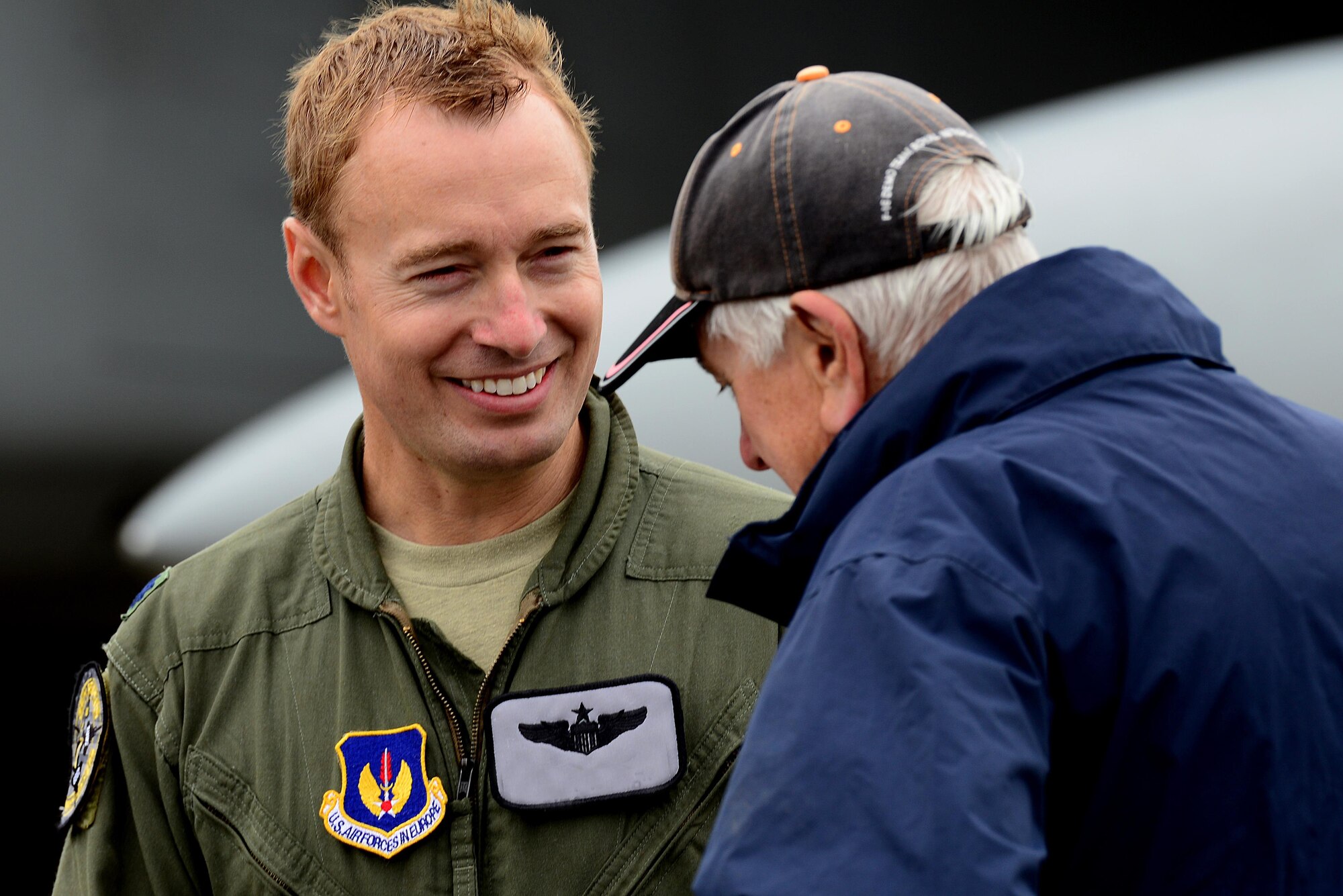 A pilot from the 493rd Fighter Squadron, Royal Air Force Lakenheath speaks with attendees about the U.S. Air Force during Friends & Families Day at RAF Marham, England July 20. RAF Lakenheath and RAF Mildenhall supported the event with static displays, such as the F-15D Eagle, CV-22 Osprey and the KC-135R Stratotanker. (U.S. Air Force photo/ Tech. Sgt. Matthew Plew)