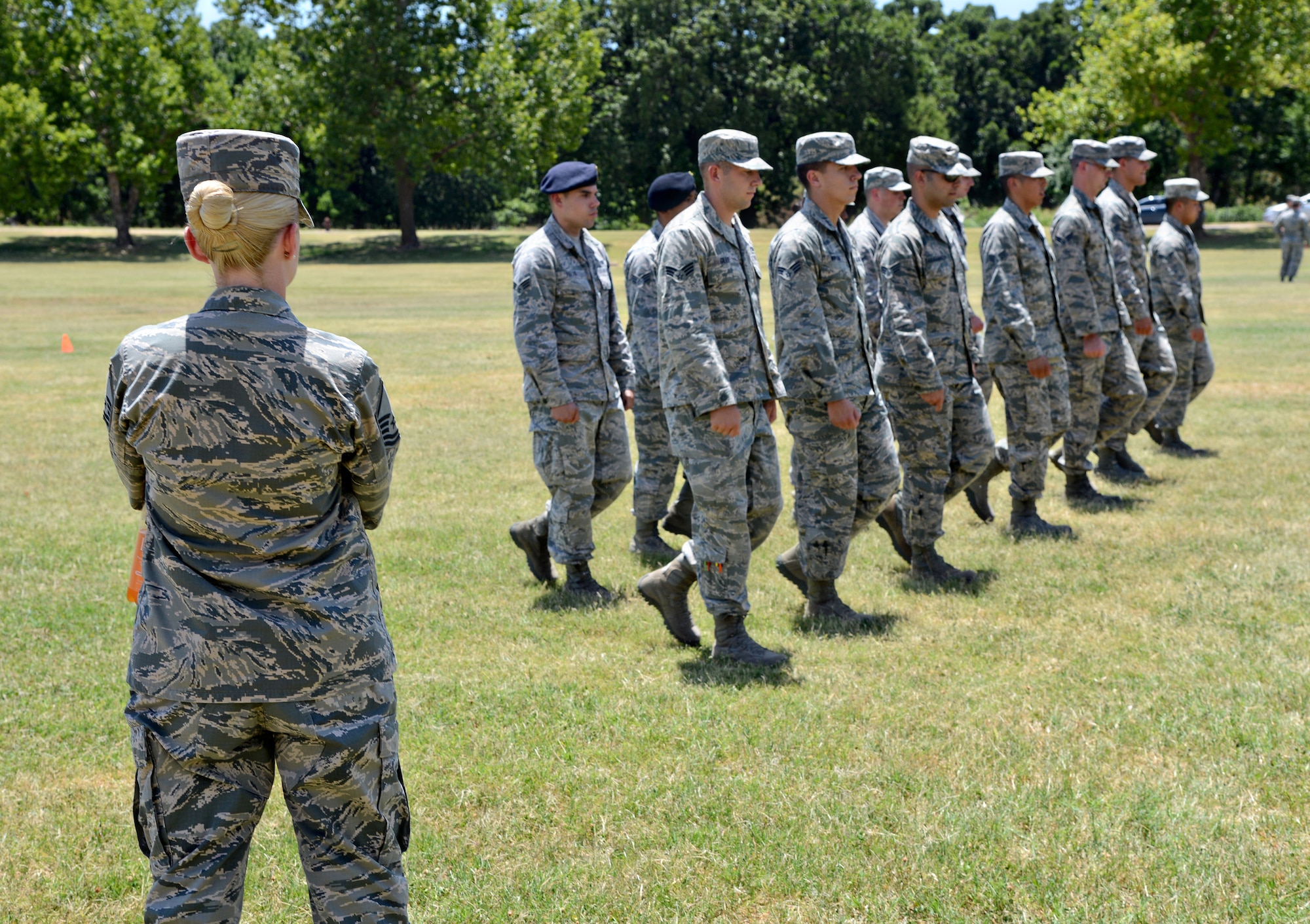 Master Sgt. Rachael Long, one of four Airman Leadership School instructors, evaluates her flight as they display their drill formations. As part of Military Customs and Courtesies curriculum, the students spend numerous hours practicing for their drill evaluations. Each student has the opportunity to lead their flight, calling out drill commands around the field beside the ALS schoolhouse. The flights practice on their own time, leading up to the practice evaluation with their instructor, allowing time to correct and hone their skills until the day of their final evaluation. This part of their curriculum helps the students refresh skills they may not have used since basic training and understand the importance of a practice rich in military history and tradition. (Air Force photo by Kelly White)