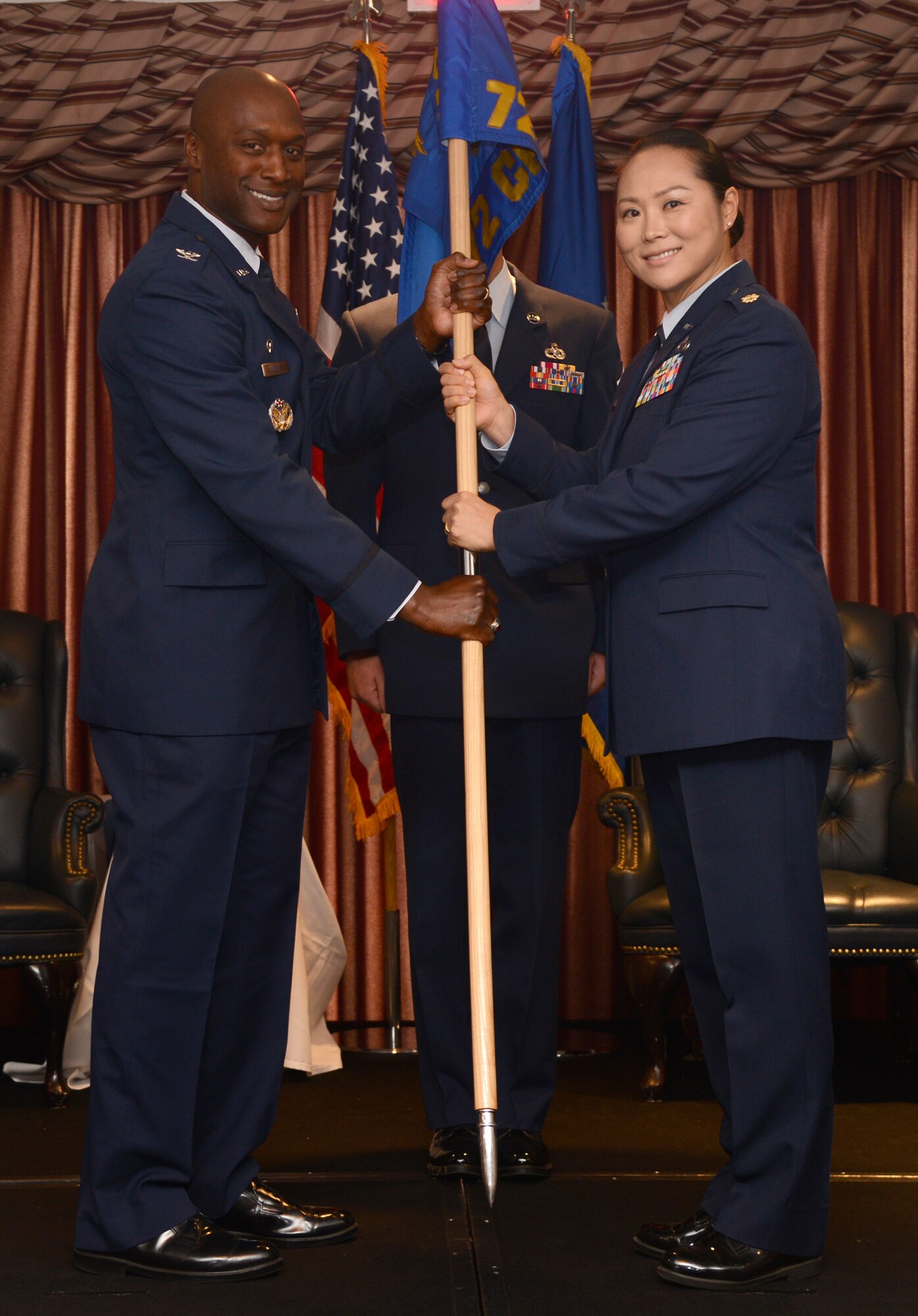 Col. Kenyon Bell, 72nd Air Base Wing commander, passes the guidon of the 72nd Comptroller Squadron to Maj. Yesun Yoon during a change of command ceremony July 12 at the Tinker Club. As the squadron commander, Major Yoon will be responsible for 194 Comptroller and Wing Staff Agency personnel. As chief financial officer of the 72nd Air Base Wing, she will plan and execute a $307 million operating budget and provide financial customer service to more than 65,000 military, civilians, retirees and Reserve personnel. The squadron certifies over $15 billion annually for the Oklahoma City Air Logistics Complex, 552nd Air Control Wing, Navy Strategic Communication WingONE, 507th Air Refueling Wing and 45 other associate units. (Air Force photo by Kelly White)
