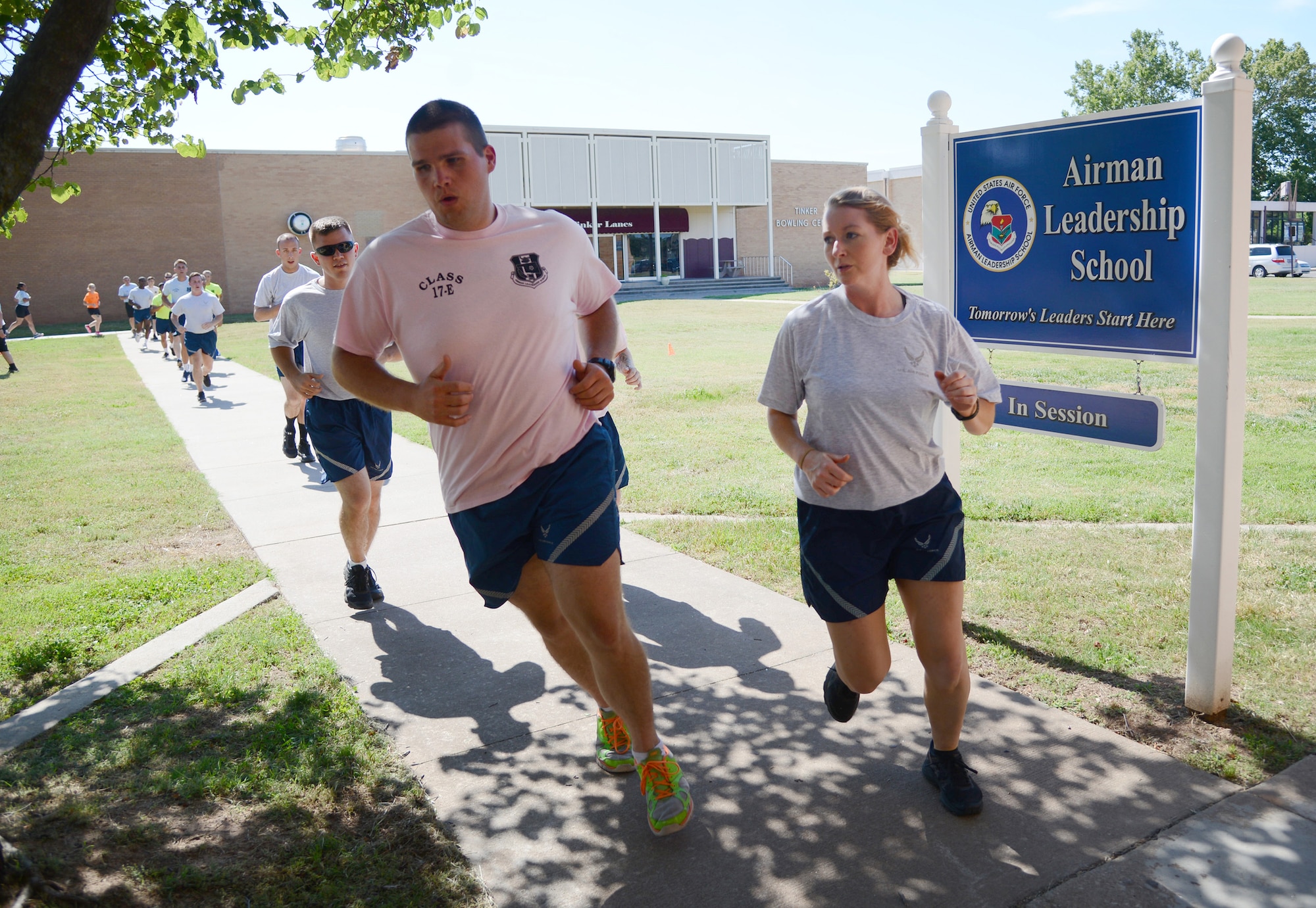 Senior Airman Evan Wilson, 963rd Airborne Air Control Squadron, and class leader Senior Airman Rebecca Cowan, 507th Operations Support Squadron, along with the rest of Class 17-E, run laps in front of the ALS schoolhouse during PT. ALS holds PT four days per week, with a Commandant’s PT on Fridays. (Air Force photo by Kelly White)