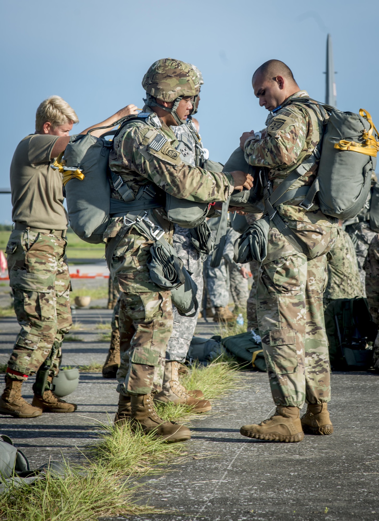 Service members from MacDill Air Force Base, Fla., put their parachute gear on before their flight in Brooksville, Fla., July 15, 2017. Before a service members can jump, they must run through safety instructions and procedures. (U.S. Air Force photo by Senior Airmen Mariette Adams)