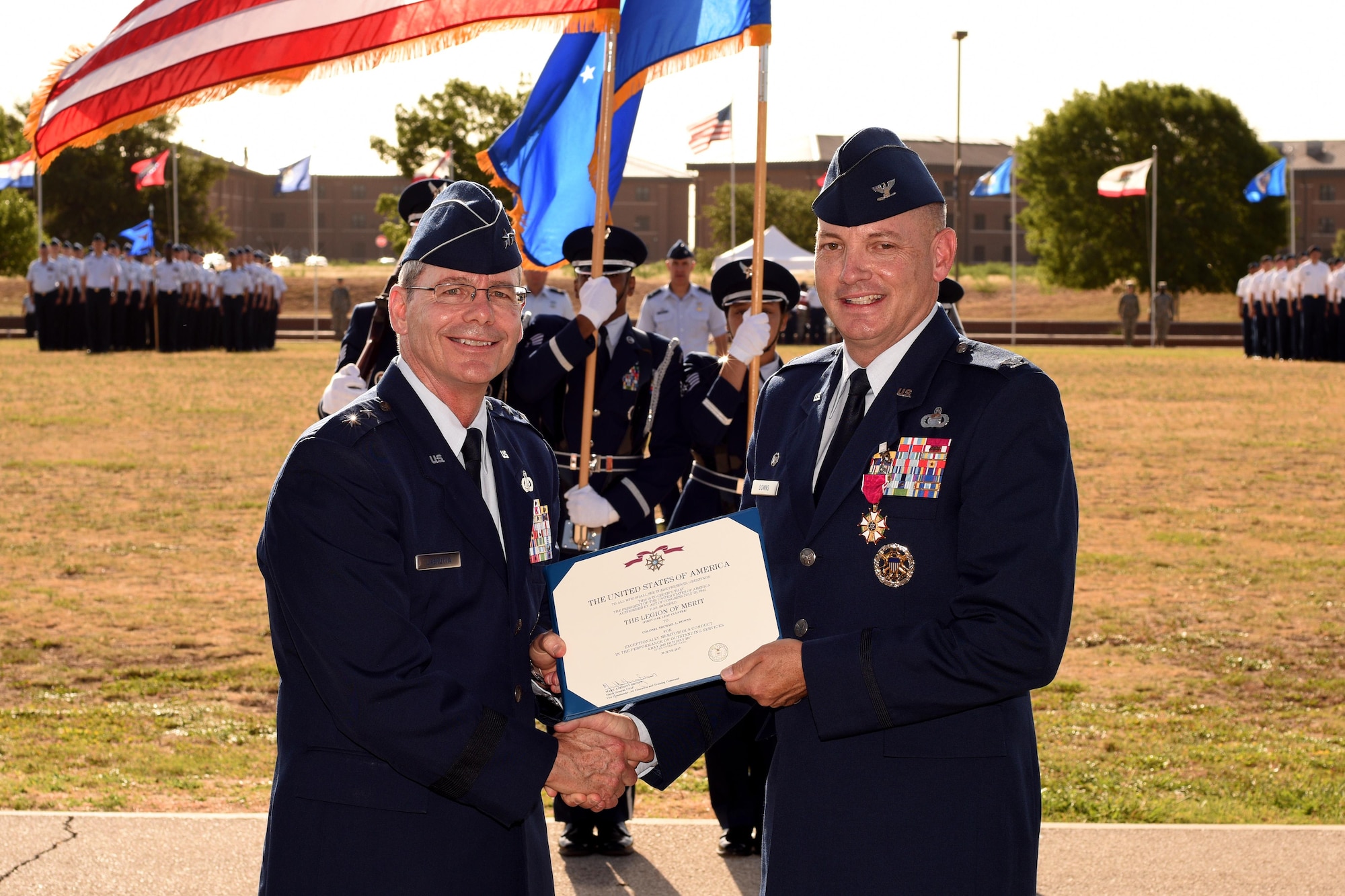 U.S. Air Force Maj. Gen. Robert LaBrutta, 2nd Air Force Commander, presents the Legion of Merit certificate to Col. Michael Downs, 17th Training Wing Commander, at the parade field on Goodfellow Air Force Base, Texas, July 21, 2017. Downs was the 45th base commander and commands four groups, including three geographically separated units, with the mission, “Develop Exceptional Intelligence, Surveillance and Reconnaissance and Fire Protection Professionals for America and Her Allies.” (U.S. Air Force photo by Airman 1st Class Randall Moose/Released)