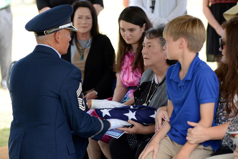 Chief Master Sgt. Kevin Terrell, retired, presents the American Flag to Madeline Emrick, family member of Airman 1st Class Phillip Emrick, during his funeral July 14. Final Salute, a pilot course recently held on a voluntary basis for members of the Tinker Honor Guard, emphasizes professional development through the importance of honoring those who have served at military funerals and based upon the book, “The Final Salute.”