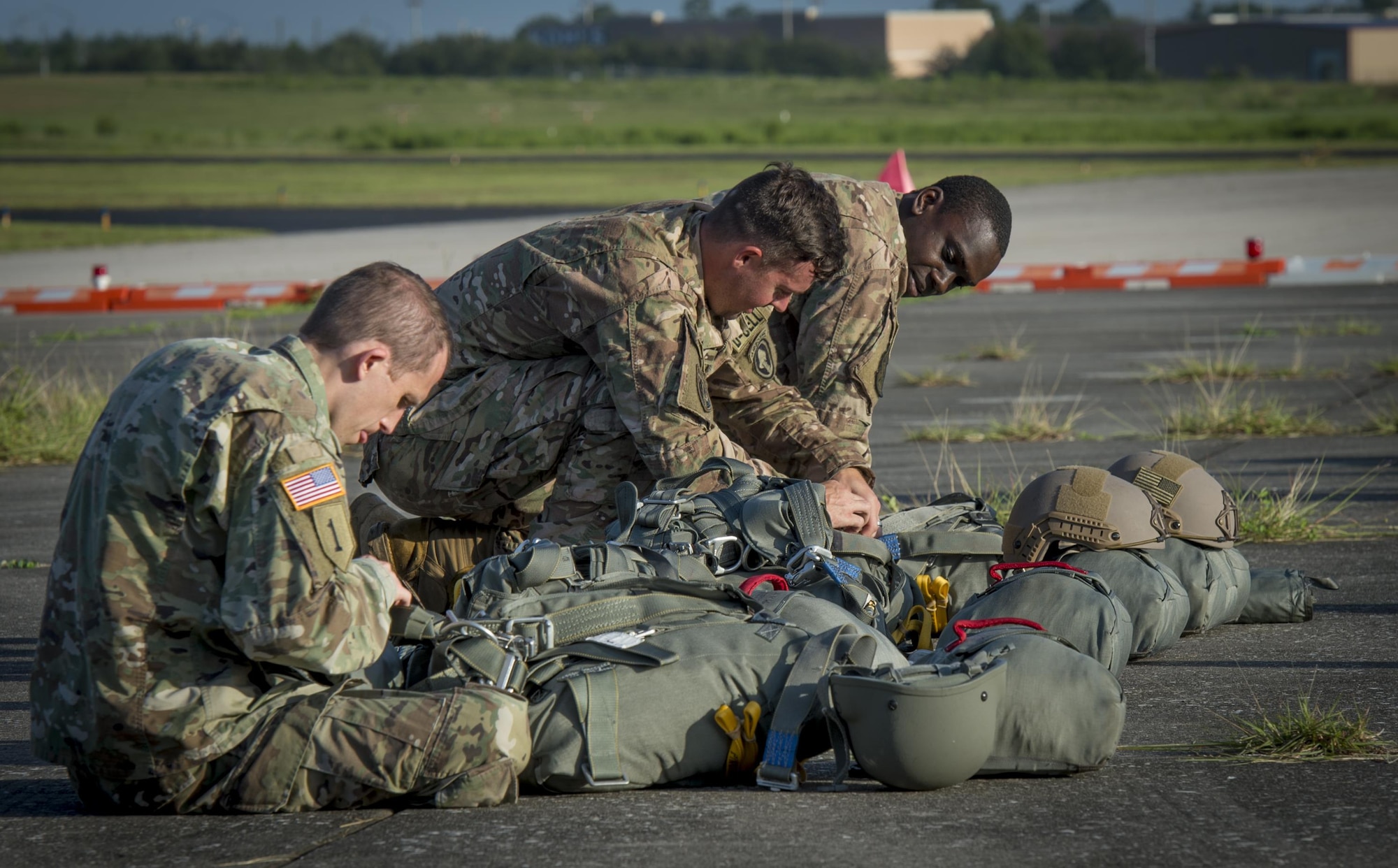 Service members from MacDill Air Force Base, Fla., prepare their gear before their flight in Brooksville, Fla., July 15, 2017. Service members must run through safety procedures and check parachutes before jumping. (U.S. Air Force photo by Senior Airmen Mariette Adams)