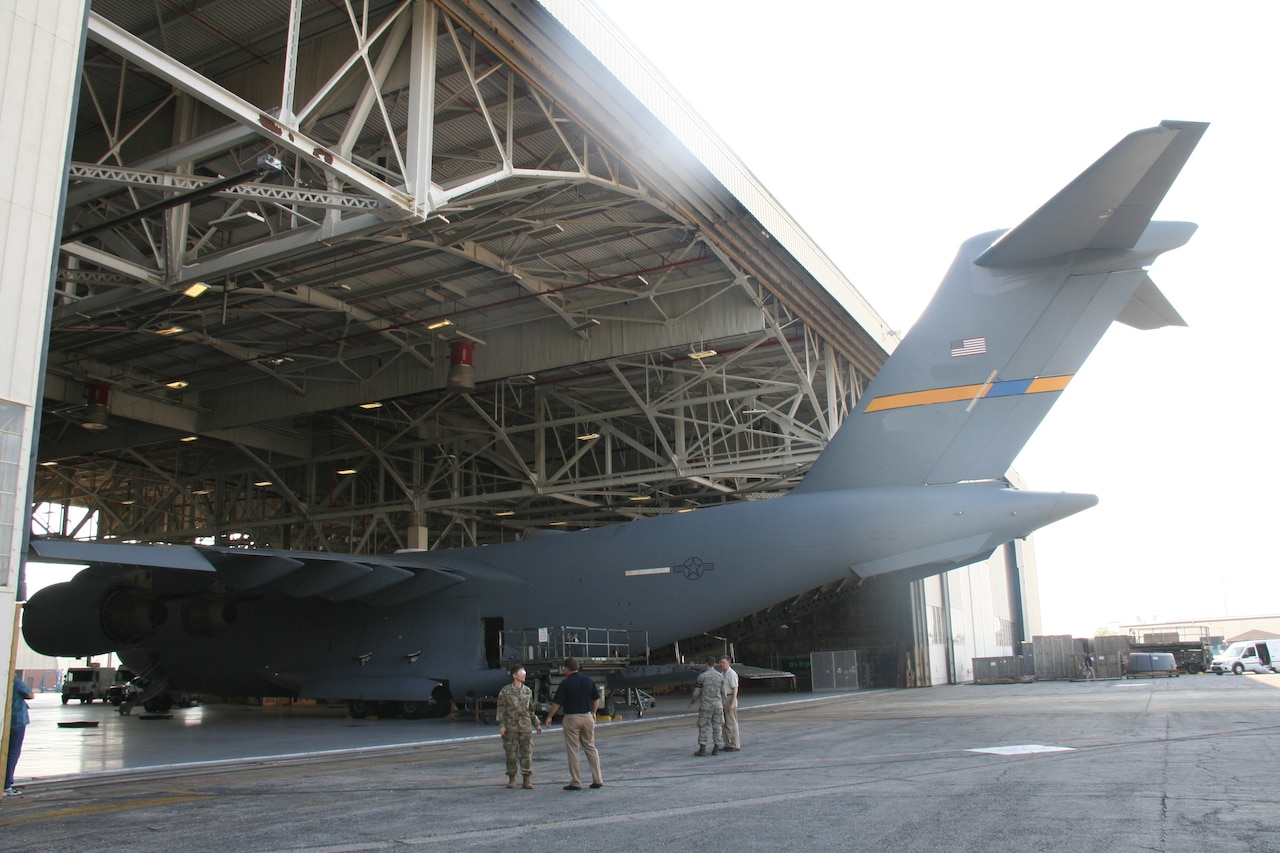 In support of Global Response Force missions, this Air Force C-17 aircraft is being integrated with the Army's En Route Mission Command Fixed Installed Satellite Antenna at Joint Base Charleston, S.C., May 12, 2017. Air Force Capt. Dawn Wyant, EMC project lead for Project Manager Warfighter Information Network-Tactical, left, discusses the integration with an industry partner. Army photo by Amy Walker