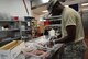Tech. Sgt. Cyrus Blades, 105th Airlift Wing services Airman, prepares a meal for Northern Lightning 2017 participants at Volk Field Air National Guard Base, Camp Douglas, Wis., May 9, 2017. The 40 services Airmen and Soldiers from across the nation prepared meals for approximately 6,500 exercise participants during the two-week exercise. (U.S. Air National Guard photo by Staff Sgt. Andrea F. Rhode)