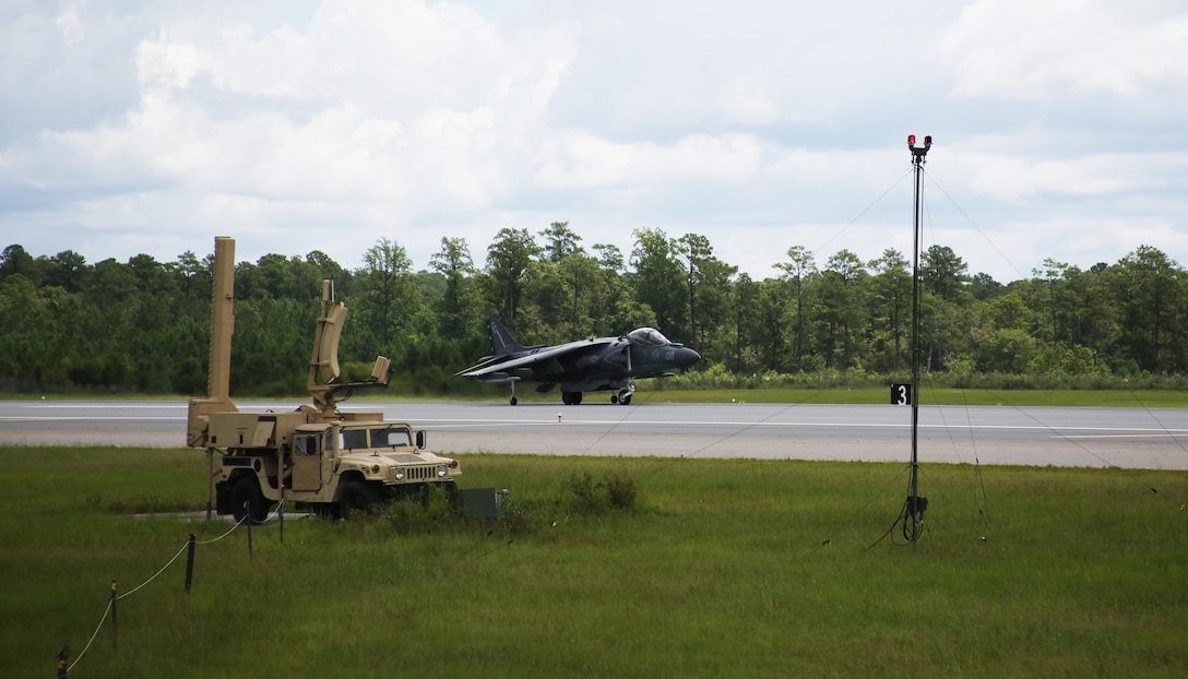 An AV-8B Harrier II lands on the runway next to the Air Traffic Navigation, Integration, and Coordination System at Marine Corps Air Station Cherry Point, N.C., July 19, 2017. The aircraft was tracked by the ATNAVICS before communication was transferred to Marines manning the air traffic control tower aboard the air station.  The Harrier is from Marine Attack Squadron 231, Marine Aircraft Group 14, 2nd Marine Aircraft Wing and MACS-2 is assigned to Marine Air Control Group 28, 2nd MAW. (U.S. Marine Corps Photo by: Pfc. Skyler Pumphret/ Released)