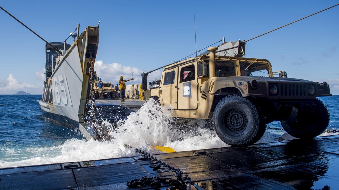 Navy Petty Officer 3rd Class Sirus Woodard directs a Humvee onto a landing craft utility from the USS Ashland as part of an amphibious assault during Talisman Saber 17 in the Coral Sea, July 19, 2017. The  exercise off Australia's coast focuses on strengthening the U.S.-Australia alliance. Navy photo by Petty Officer 3rd Class Jonathan Clay