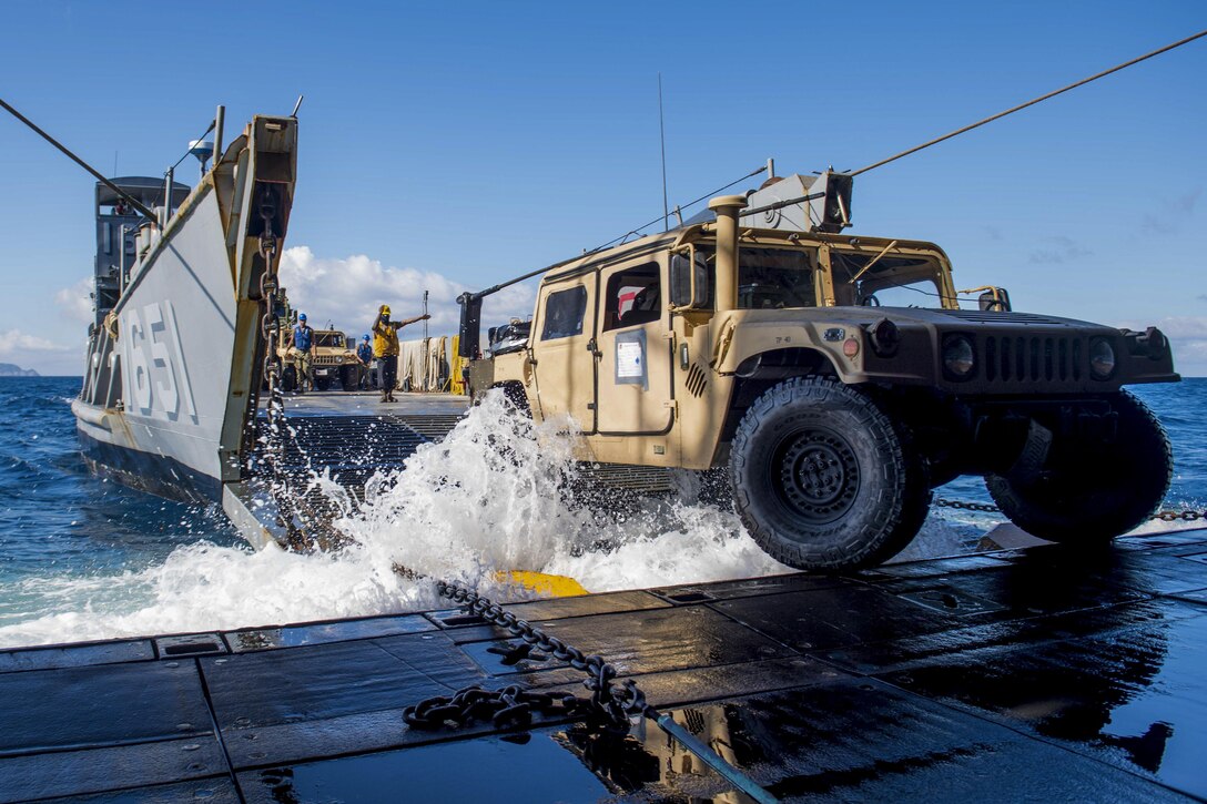 Navy Petty Officer 3rd Class Sirus Woodard directs a Humvee onto a landing craft utility from the USS Ashland as part of an amphibious assault during Talisman Saber 17 in the Coral Sea, July 19, 2017. The  exercise off Australia's coast focuses on strengthening the U.S.-Australia alliance. Navy photo by Petty Officer 3rd Class Jonathan Clay