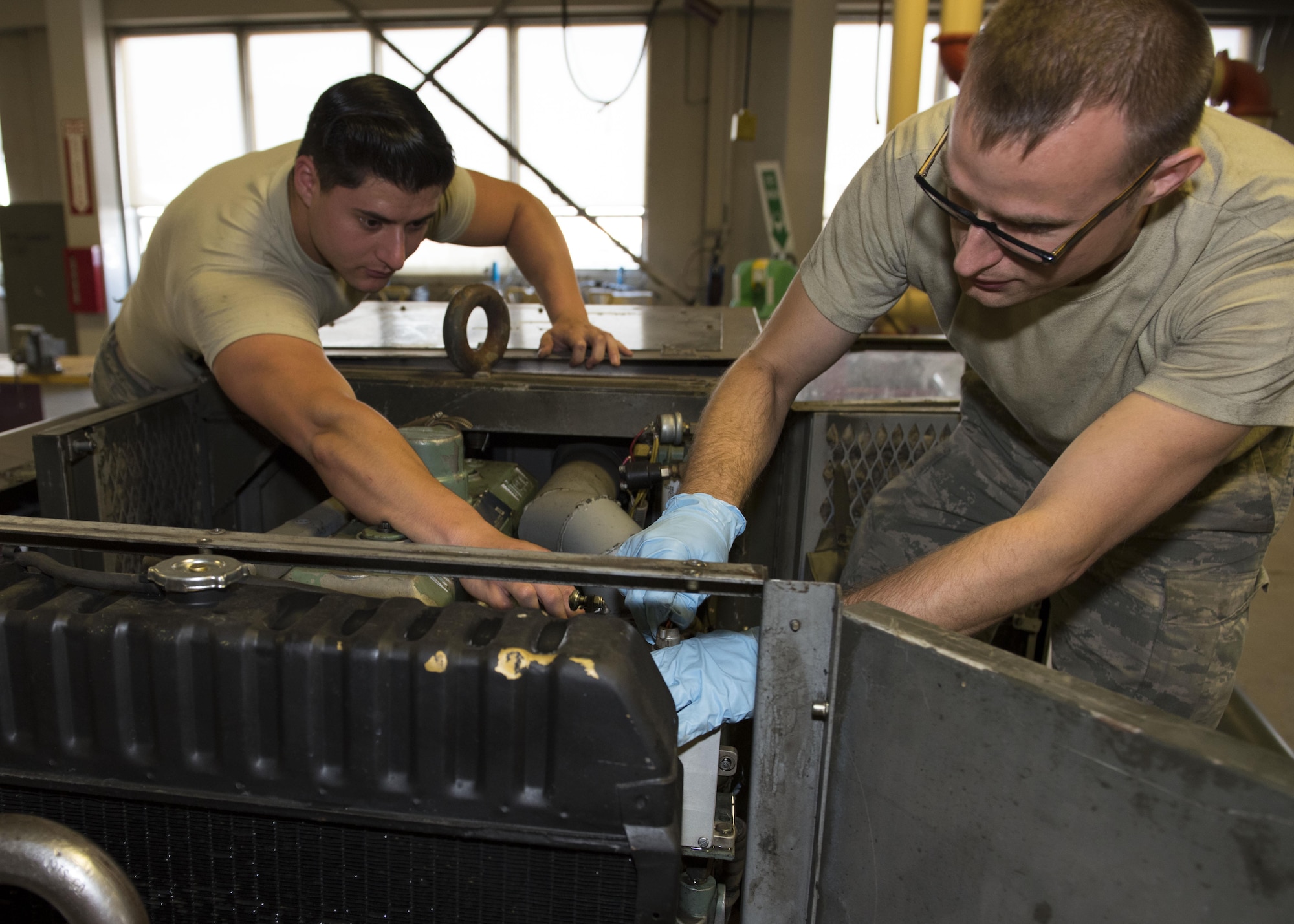 Senior Airman Austin Ready, 92nd Aerospace Ground Equipment journeyman and Staff Sgt. Brandon Baltis, 92nd AGE craftsman, test the connections and fittings on a power generator cart July 19, 2017, at Fairchild Air Force Base, Washington. Powerful mobile generators are necessary to provide aircraft with enough power to cold-start its engines. (U.S. Air Force photo / Airman 1st Class Ryan Lackey)