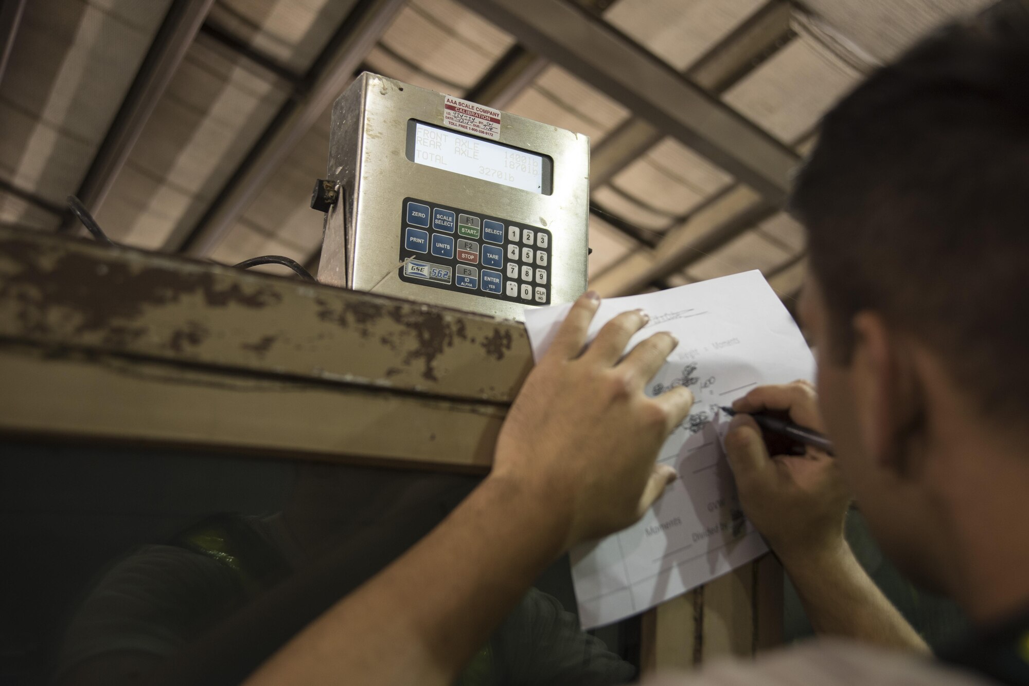 Airman 1st Class Dillon Walker, 4th Logistics Readiness Squadron travel management office, completes paperwork for cargo July 20, 2017, at Seymour Johnson Air Force Base, North Carolina. The cargo is weighed based on its front and rear axle to ensure it can safely be loaded onto an aircraft. (U.S. Air Force photo by Tech. Sgt. David W. Carbajal)