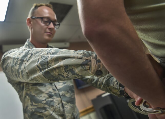 Airman 1st Class Aleksander Koziol, 437th Maintenance Squadron crew chief, handcuffs a simulated assailant during augmentee training at Joint Base Charleston, S.C., July 18, 2017. Augmentees attend a basic course for security forces procedures in case they are called to staff entry control points or conduct other security forces duties. 