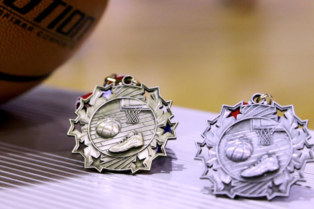 First and second place winners of the Headquarters and Headquarters Squadron basketball tournament receive a medal at Marine Corps Air Station Cherry Point, N.C., July 21, 2017.The tournament was comprised of ten teams from different sections within H&HS. The revenue generated from the tournament lowered the ticket prices for the squadron’s annual Marine Corps ball. (U.S. Marine Corps photo by Cpl. Jason Jimenez/ Released)