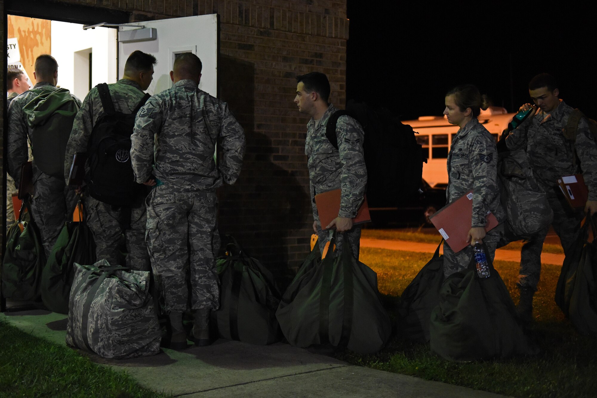 Team Seymour Airmen carry their deployment bags to the pre-deployment function processing center during Exercise Thunderdome 17-02, July 20, 2017, at Seymour Johnson Air Force Base, North Carolina. Seymour Johnson AFB members simulate deployments and other major events to test and improve readiness and capabilities. (U.S. Air Force photo by Senior Airman Ashley Maldonado)