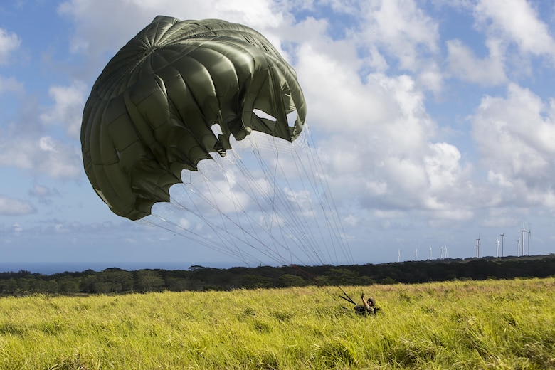 SCHOFIELD BARRACKS – A Marine with 4th Force Reconnaissance Company handles his parachute after successfully conducting a static line airborne jump at Schofield Barracks, July 14, 2017. The Marines trained with U.S. Army Special Forces to maintain proficiency in completing static line and high altitude free fall airborne jumps. (U.S. Marine Corps photo by Lance Cpl. Isabelo Tabanguil)