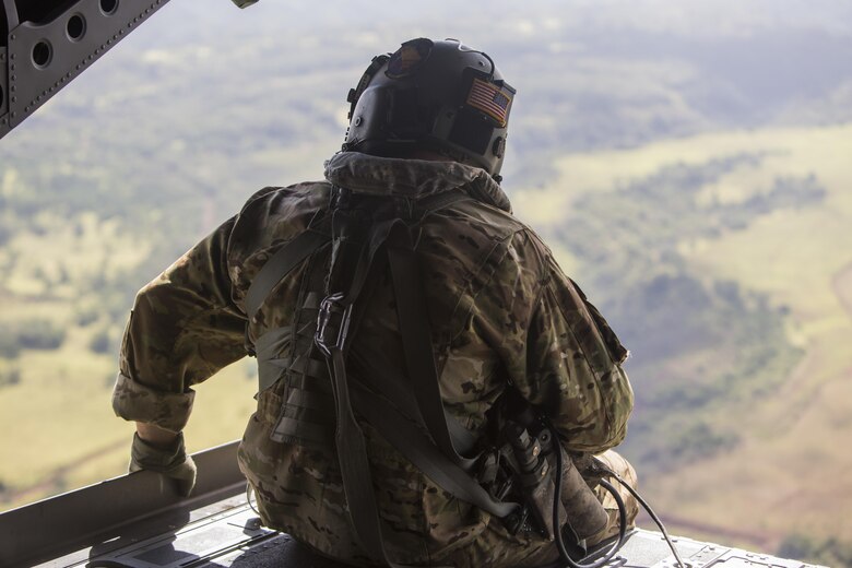 SCHOFIELD BARRACKS – A U.S. Army crew chief observes the outside of a CH-47 Chinook helicopter during a high altitude airborne jump at Schofield Barracks, July 14, 2017. Marines with 4th Force Reconnaissance Company trained with U.S. Army Special Forces to maintain proficiency in completing static line and high altitude free fall airborne jumps. (U.S. Marine Corps photo by Lance Cpl. Isabelo Tabanguil)