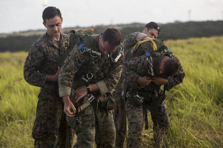 SCHOFIELD BARRACKS – Marines with 4th Force Reconnaissance Company prepare their parachutes before conducting a static line jump at Schofield Barracks, July 14, 2017. The Marines trained with U.S. Army Special Forces to maintain proficiency in completing static line and high altitude free fall airborne jumps. (U.S. Marine Corps photo by Lance Cpl. Isabelo Tabanguil)