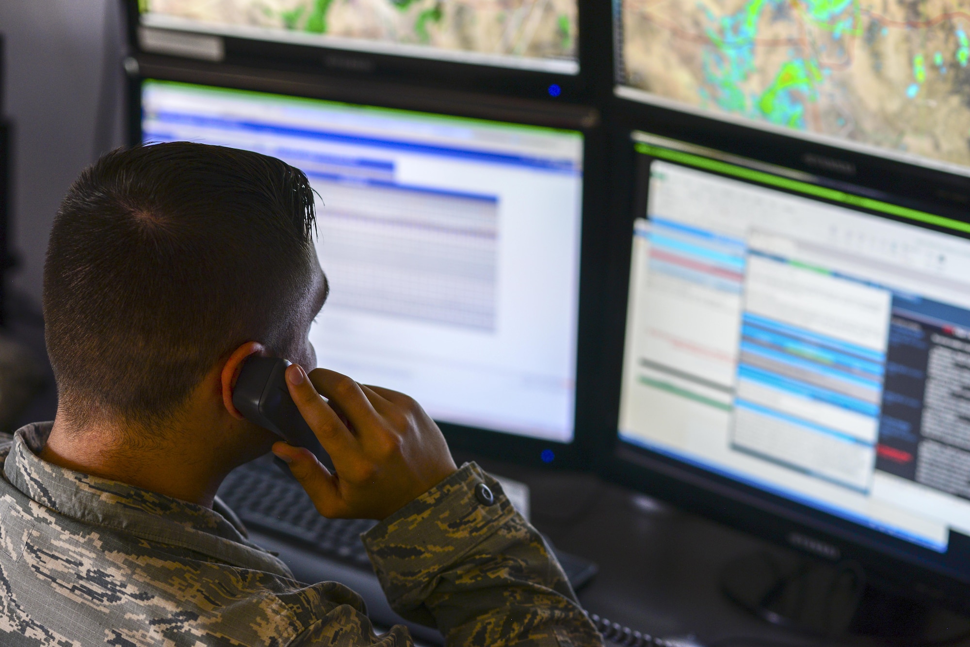 U.S. Air Force Airman 1st Class Cody Leahy, 25th Operational Weather Squadron forecaster, answers a phone call at Davis-Monthan Air Force Base, Ariz., July 19, 2017. Leahy was responding to weather condition inquiries from Travis AFB, Calif.  (U.S. Air Force photo by Airman 1st Class Michael X. Beyer)