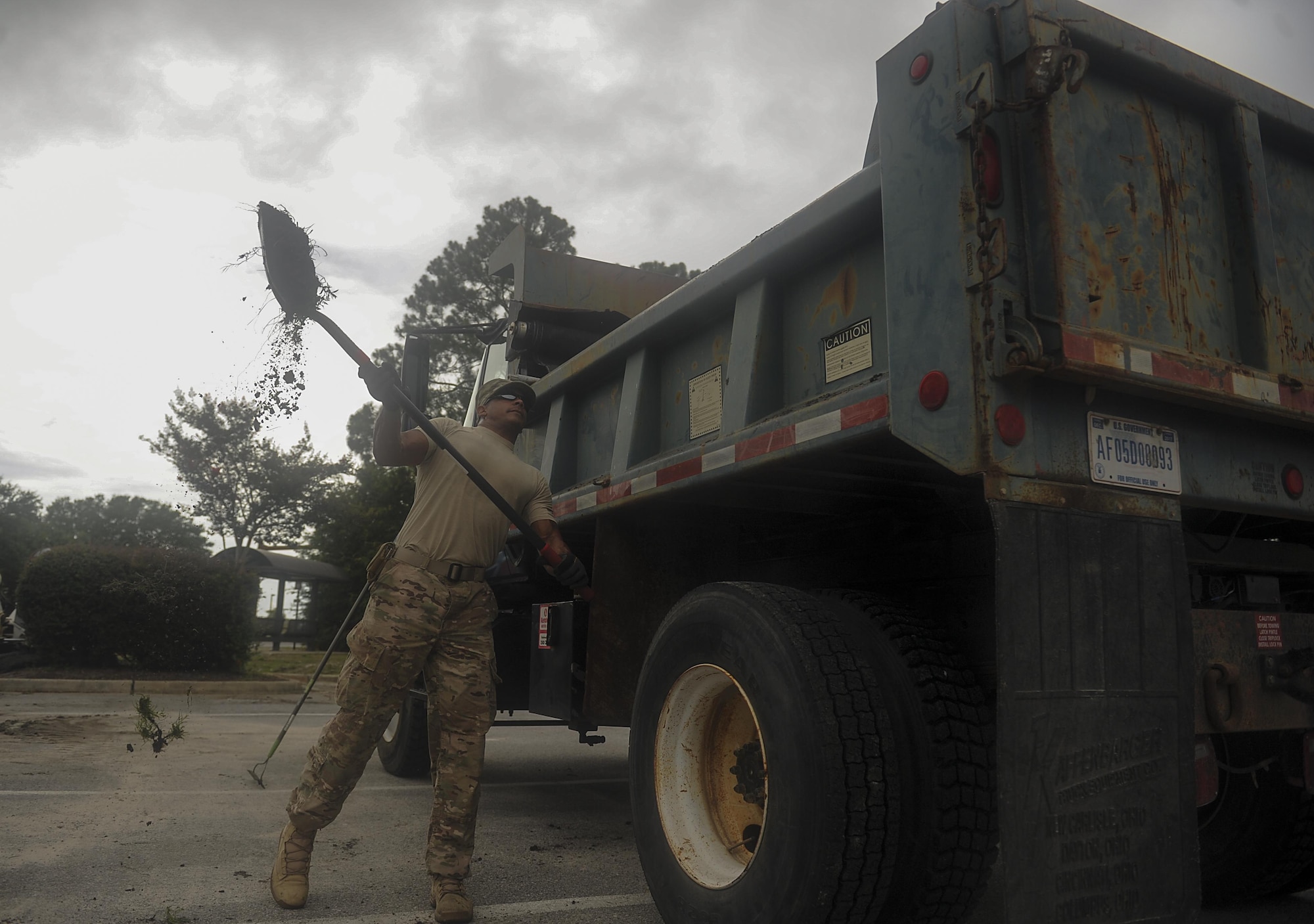 Senior Airman Jason Mohamed, a pavements and construction equipment journeyman with the 1st Special Operations Civil Engineering Squadron, throws excess dirt into a dump truck at Hurlburt Field, Fla., July 18, 2017. The “Dirt Boyz” from the 1st SOCES releveled a ditch outside the 1st Special Operations Medical Group to maintain efficient storm drains and prevent flooding during heavy rain. (U.S. Air Force photo by Airman 1st Class Rachel Yates)
