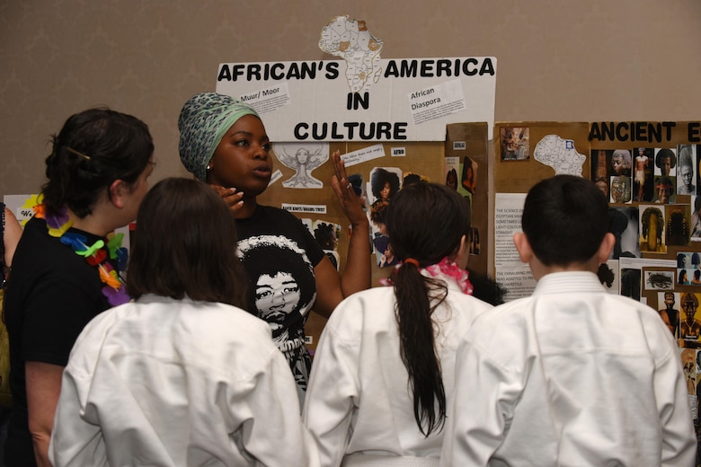 A Team V member teaches children about African-American culture during a Diversity Day event, July 21, 2017, Vandenberg Air Force Base, Calif. Throughout the day, those in attendance were treated to a variety of ethnic dances, games, and delicacies. Additionally, there were stations spread out through the PCC Ballroom with information and fun facts about each ethnic group and their contributions to culture and society. (U.S. Air Force photo by Senior Airman Robert J. Volio/Released)