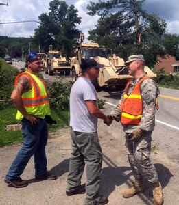 New York Army National Guard Sgt. Raymond Faltisco conducts initial linkup with Erie County Highway Department counterparts near Holland, New York following tornado storm damage on July 20, 2017. 