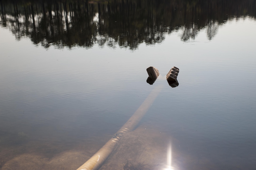 A pair of empty water cans keep a strainer afloat on MacArthur Lake for the Inland Pipeline Distribution System during QLLEX 2017, July 21, at Fort Bragg, NC. QLLEX, short for Quartermaster Liquid Logistics Exercise, is the U.S. Army Reserve’s premier readiness exercise for fuel and water distribution. This year’s QLLEX is not only a full demonstration of the capability, combat-readiness, and lethality of America’s Army Reserve to put fuel and water where it is needed most – in the vehicles and hands of the war-fighter and maneuver units – but it also further exercises the interoperability of the U.S. Army Reserve alongside active Army and British Army logisticians. (U.S. Army Reserve photo by Timothy L. Hale) (Released)